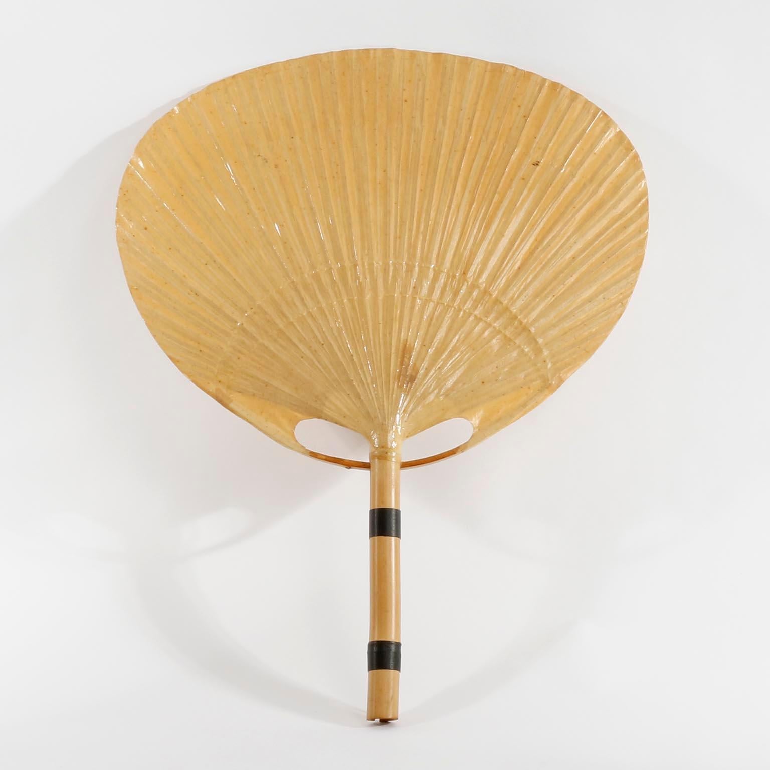 A pair of ‘Uchiwa’ wall light fixtures with large rice paper palm shaped leaves connected to a bamboo shaft by Ingo Maurer, Germany, 1970s.
This lamps were handmade of bamboo and Japanese rice paper in 1977.
Ingo Maurer’s interest in paper for