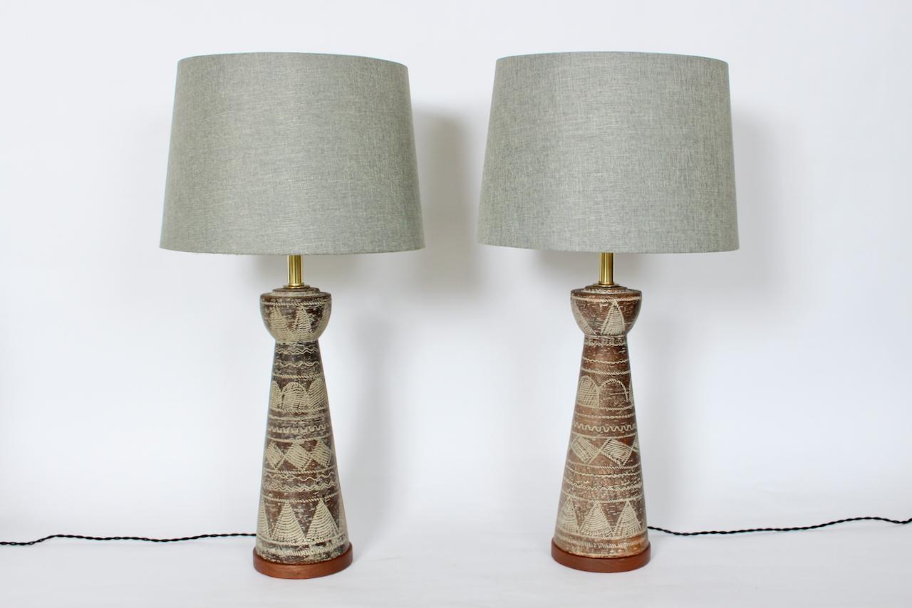 Italian Modern Ugo Zaccagnini handcrafted sgraffito Art Pottery Table Lamps. Featuring deep brown and off white textured terracotta forms, matte glazed, Brass necks, paleolithic and primitively hand incised, utilizing horizontal repeat patterning