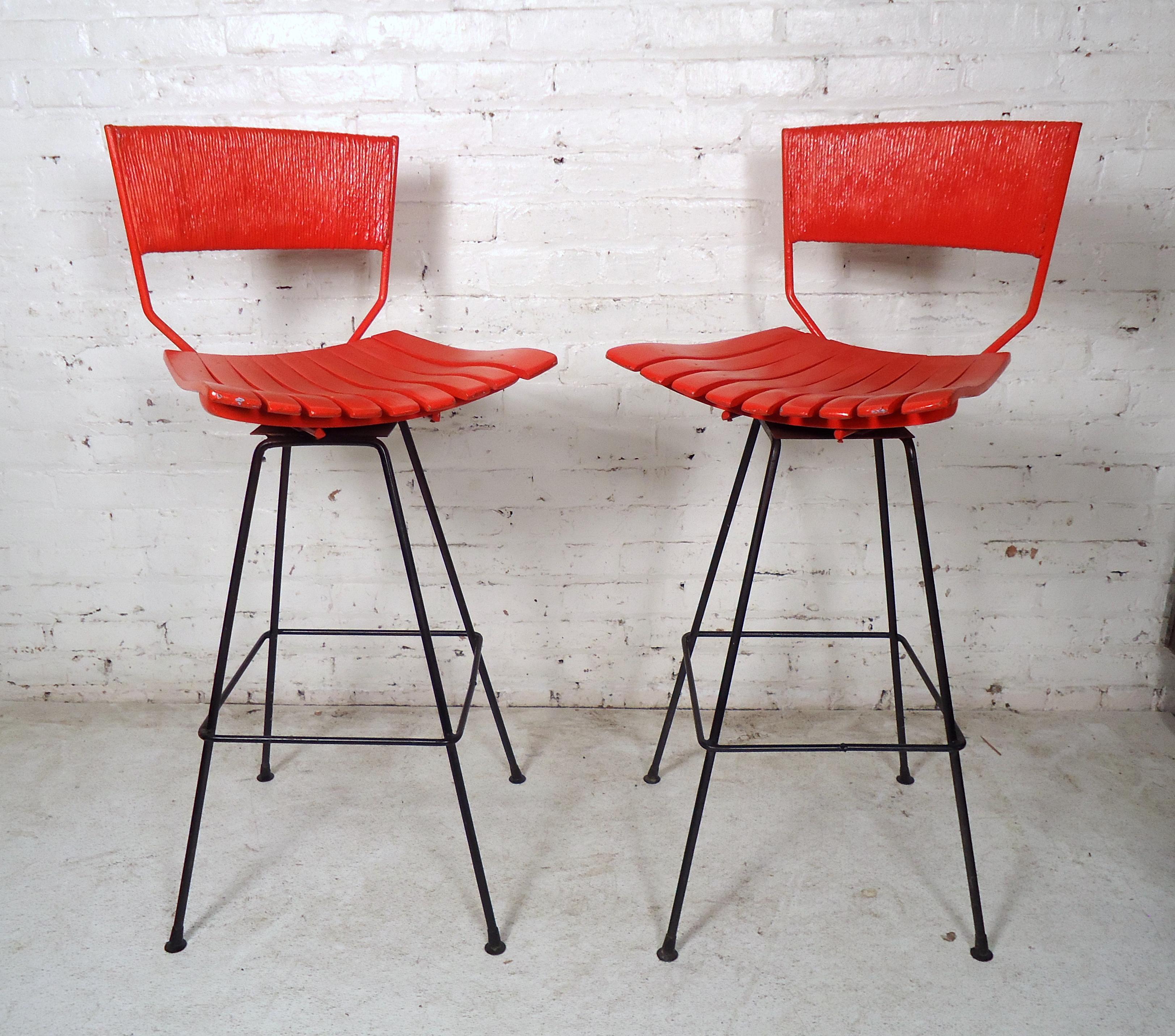 Pair of Arthur Umanoff style tall swivel bar stools these stools feature an iron base with bentwood slatted seats and a woven rush backrest painted red. The perfect addition to the midcentury environment.

Please confirm item location (NY or NJ)