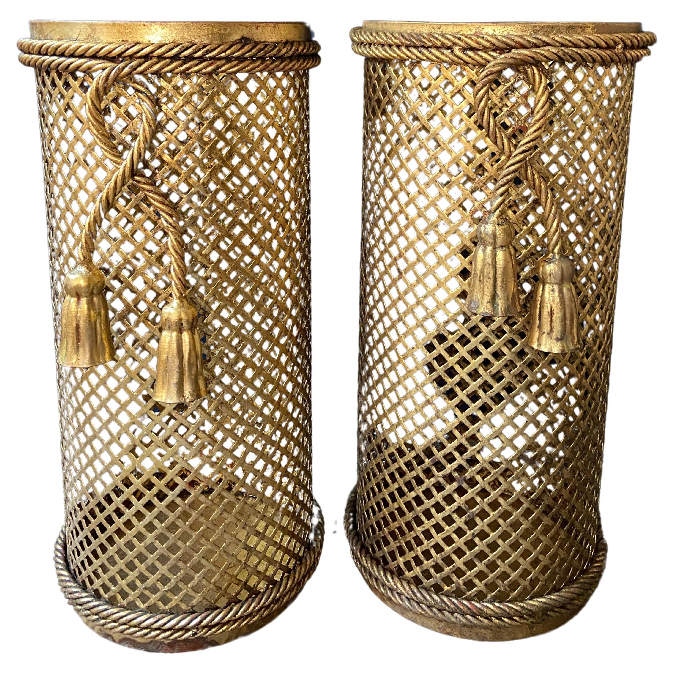 This pair of gold lacquered umbrella stands hails from Florence, Italy and was produced by renowned Li Puma Firenze in the 1950's.

The perforated lattice patterned metalwork in combination with the bent rope and tassel details give this pair a