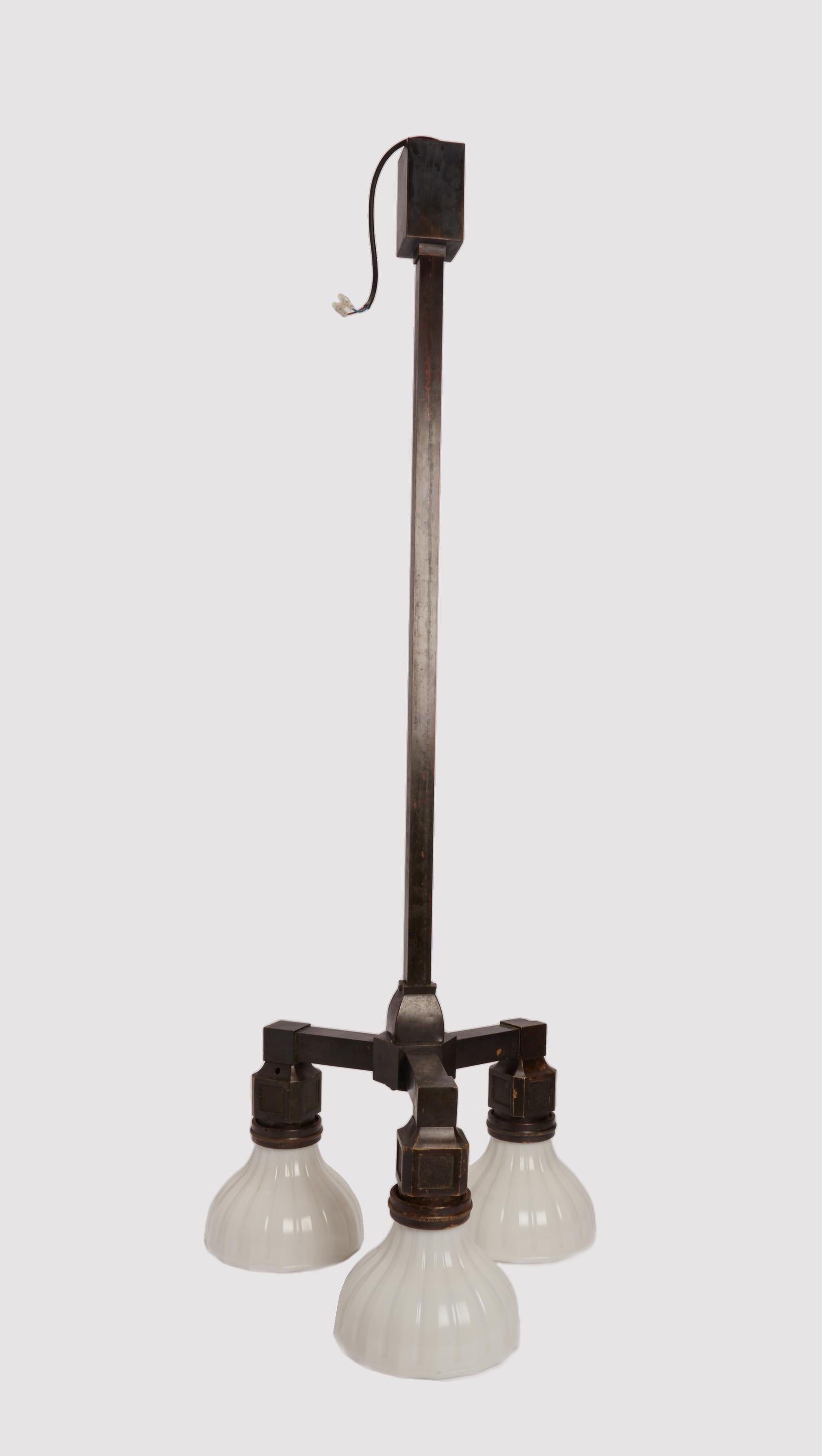 Una coppia di magnifiche lampade a sospensione, un tempo parte dell'arredamento di un sotterraneo, realizzate in bronzo e vetro opalino. USA 1910 ca.