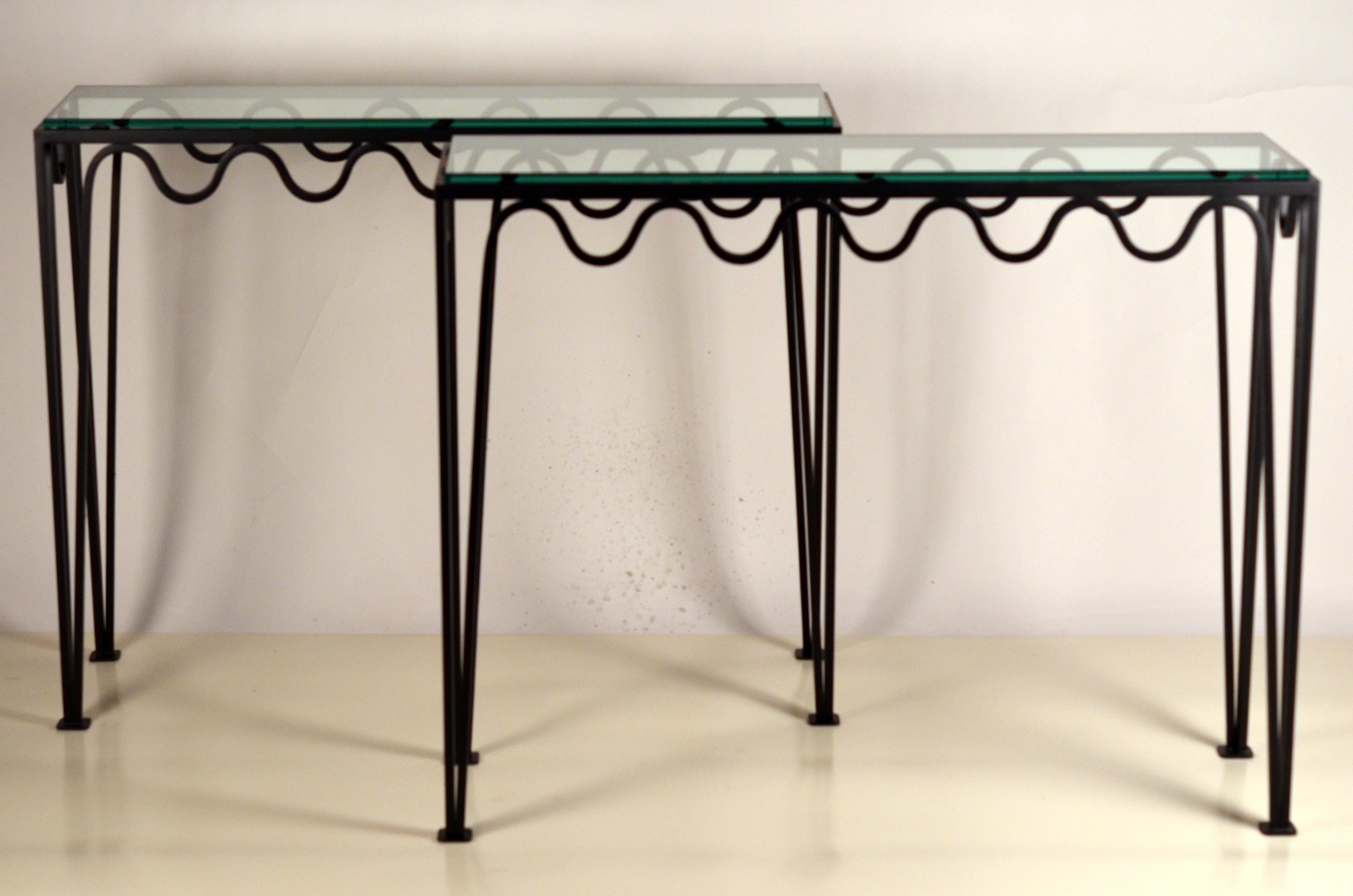 Paire de consoles ondulées en fer noirci mat et verre dans le style de Jean Royère.