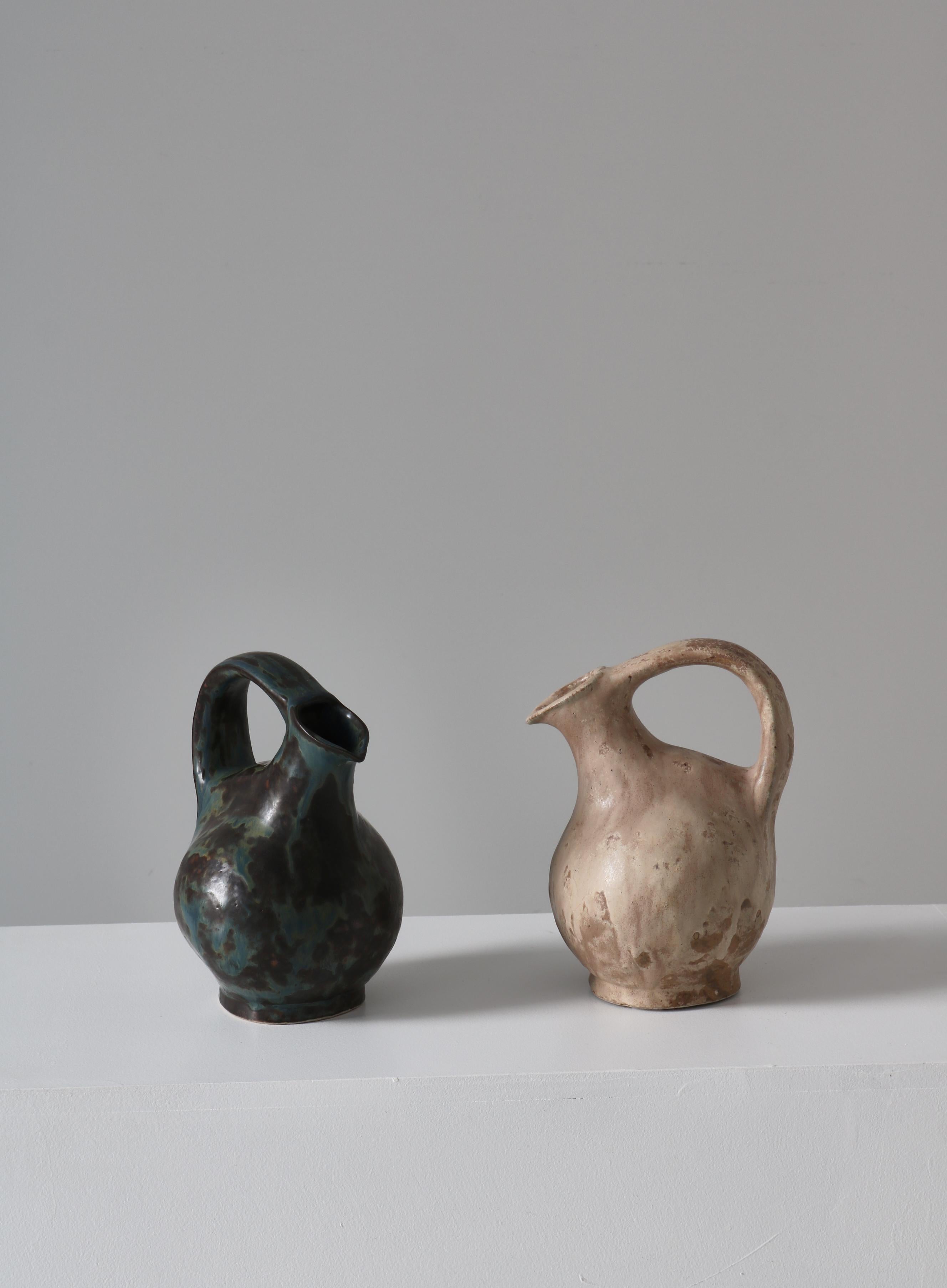 Amazing and unique early stoneware pitchers by Danish ceramic artist Bode Willumsen. Both were made at his own studio in the 1920-30s. The pieces were both hand molded by the artist himself from stoneware with a beautiful thick glazing. Signed by
