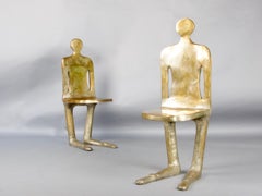 pair of unique bronze chairs representing a man and a woman