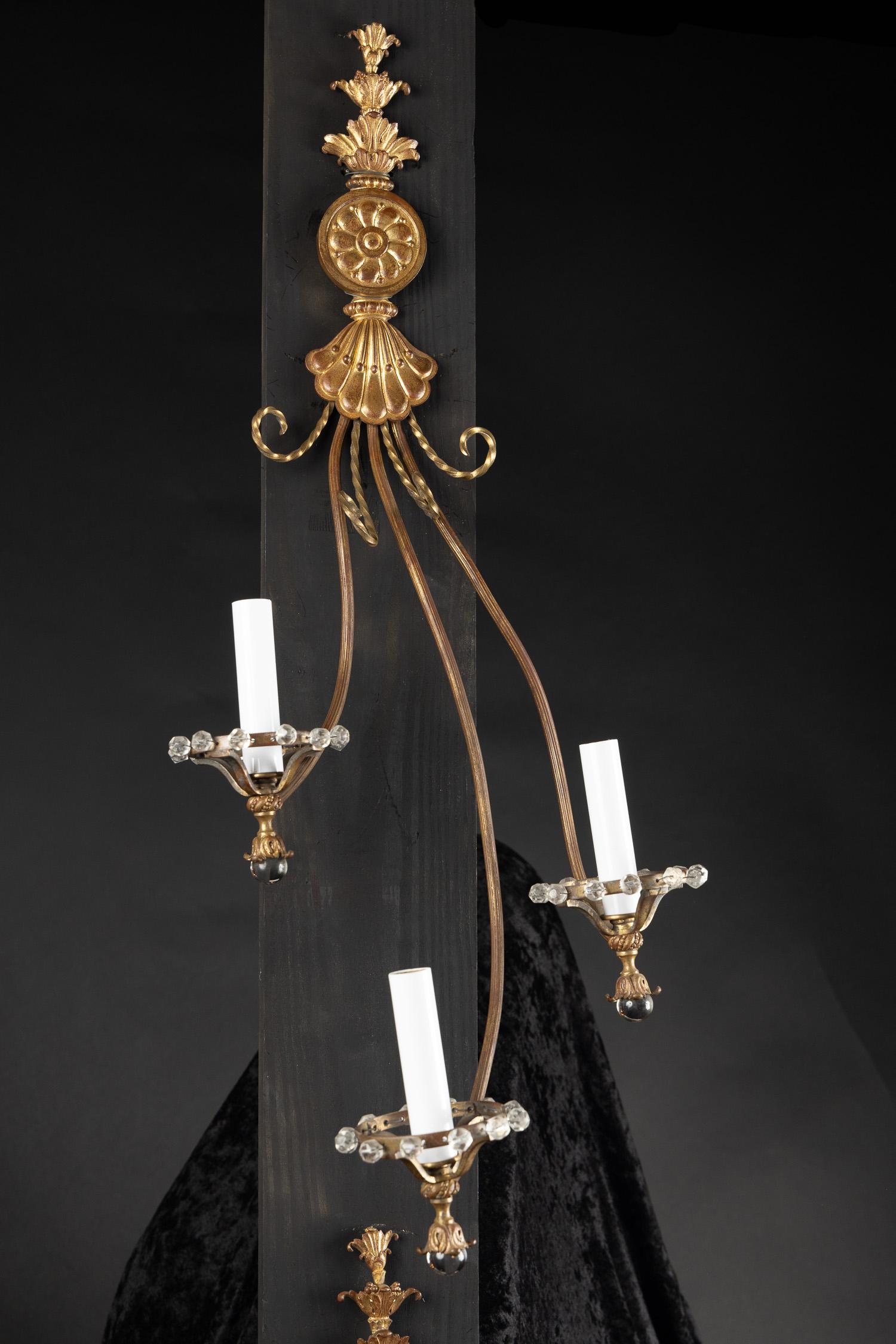 This fantastically unique pair Art Nouveau Sconces are made of bronze and feature detailed crystal elements. The pair dates back to the 20th century and is especially narrow for its length. The bronze glimmers with a patina, spiraling bronze