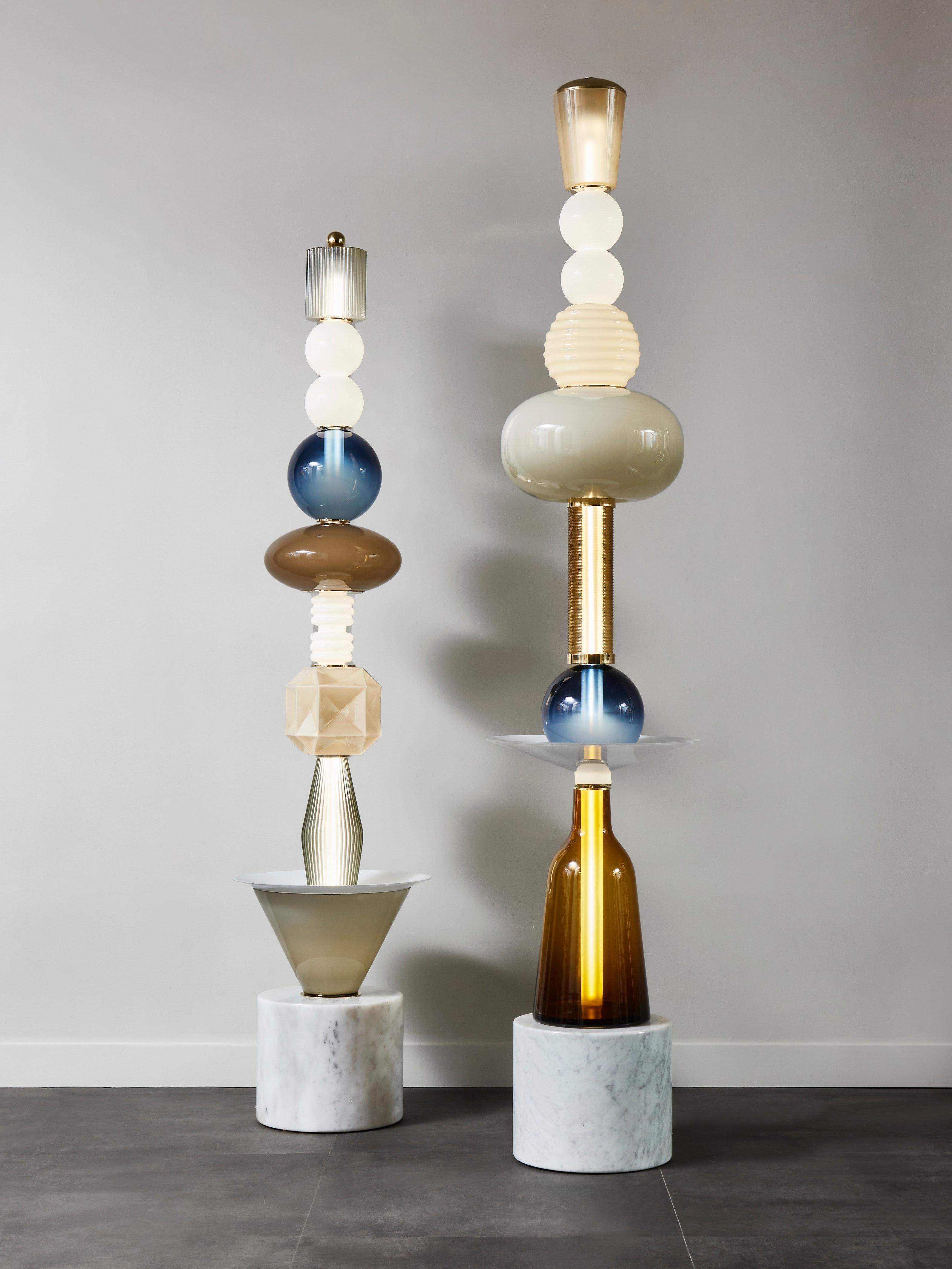 Pair of unique floor lamps by Glustin Luminaires.

Built like totem, we used a white marble base, on which come a stacking of Murano Glass pieces, each different in shape and colours.