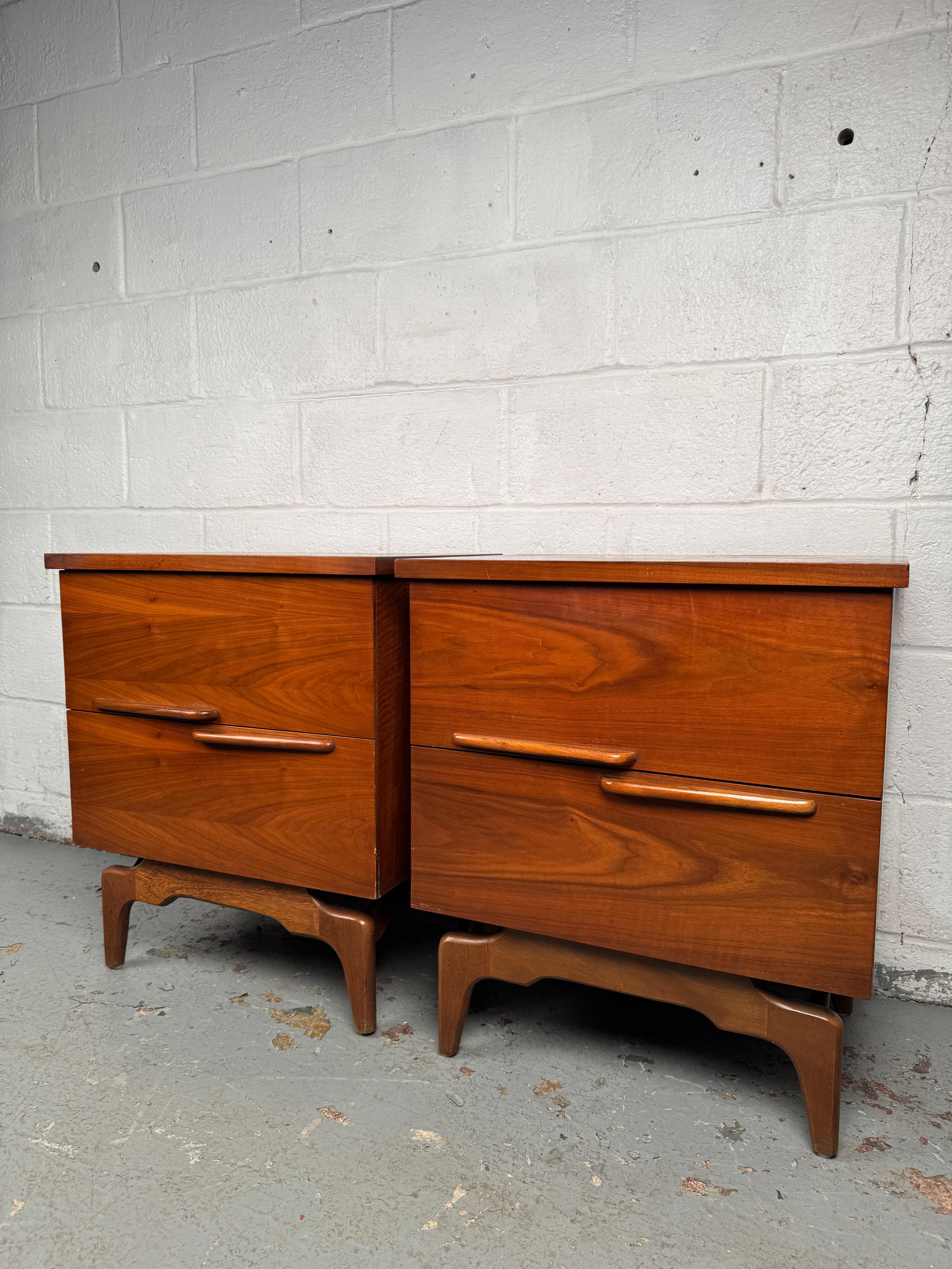 Bellissima coppia di comodini della metà del secolo scorso che sfoggiano ricche venature e linee moderne e pulite. Ogni pezzo offre un pratico spazio di archiviazione con un ingombro ridotto, rendendoli versatili per essere utilizzati come comodini