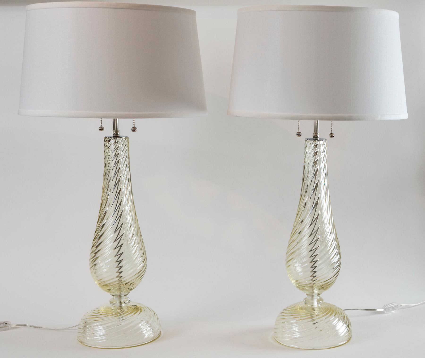 A lovely pair of delicately proportioned swirl blown lamps with a touch of citrine to make these appear more ample. These lamps are a modernized version of your classical baluster shaped table lamps.

Electrified to code with UL approved parts,