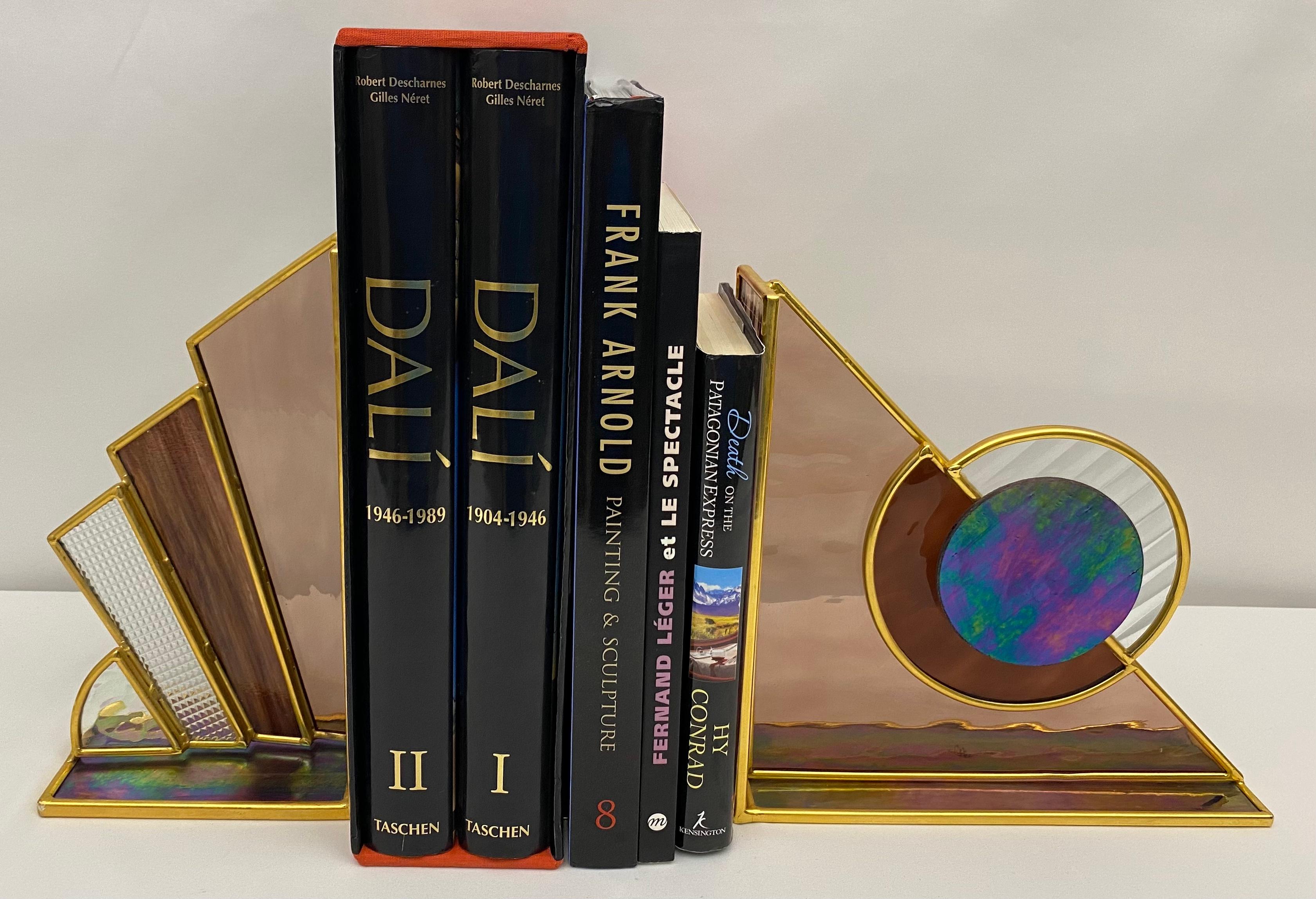 A pair of stained glass and brass bookends, good quality. 
Stunning in design, optics and color.
 
Perfect for displaying your favorite books on any shelf, dresser, table or countertop. Makes a very nice gift for oneself or others. 

Largest one
