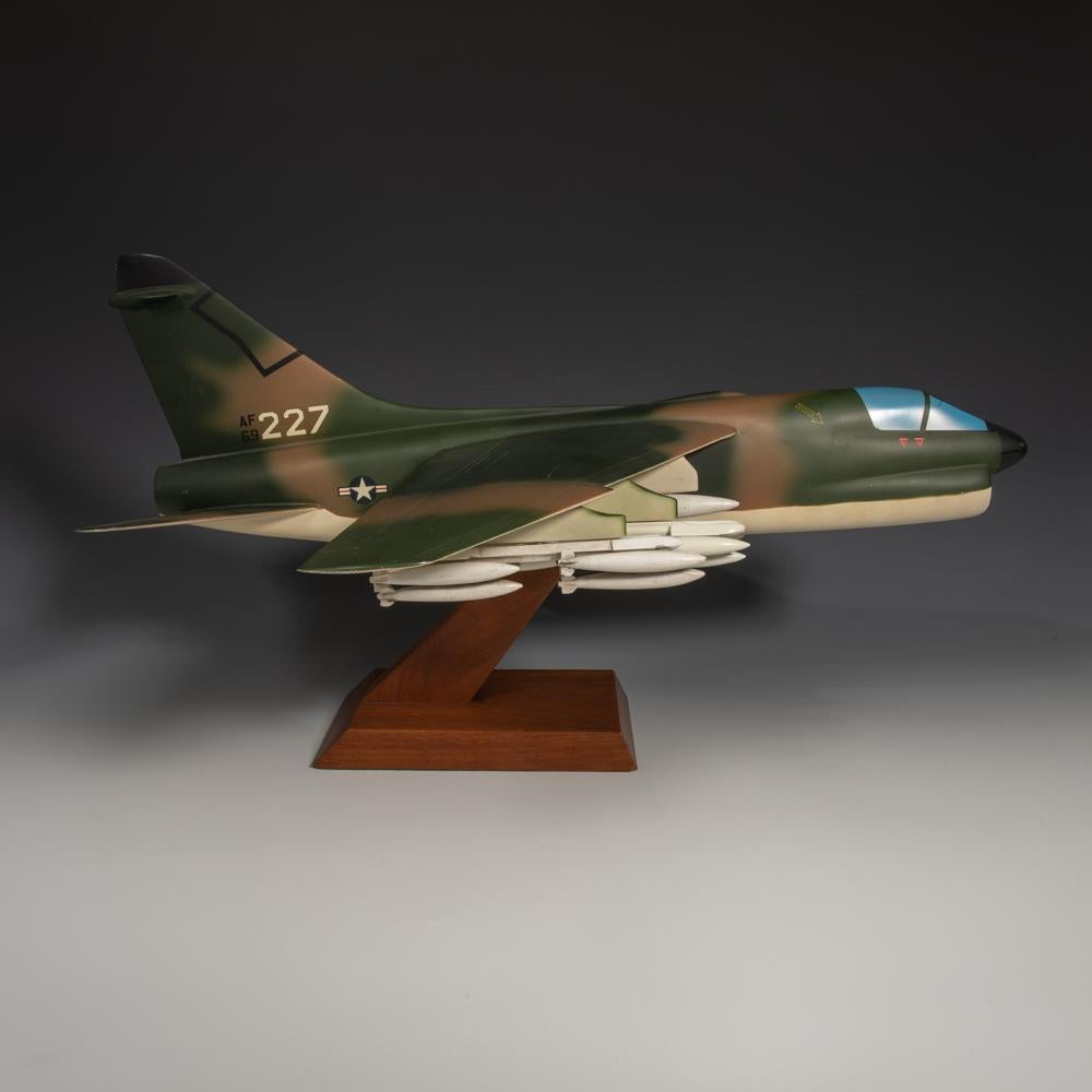 An unusual pair of painted aluminium and wood military models of the LTV ( Ling-Temco-Vought) A-7 Corsair II fighter jet airplanes. One in United States Navy (USN) livery and one in United States Air Force camouflage livery. Made by a celebrated
