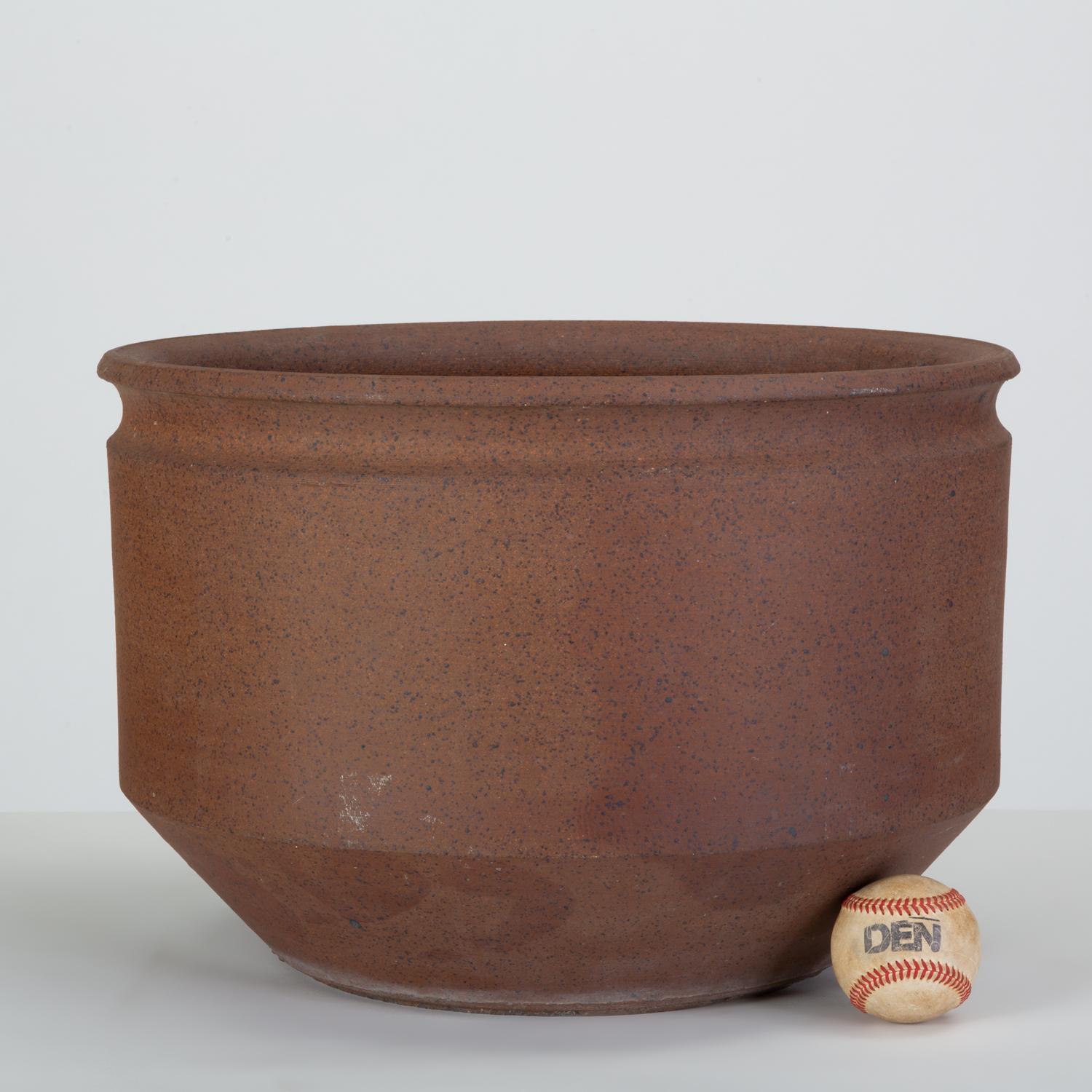 A wide, Minimalist stoneware planter from Robert Maxwell and David Cressey’s 1970s collaboration, Earthgender. This example is untextured, with flat sides angling towards the foot. A wide, notched lip is its single decorative element. We have two