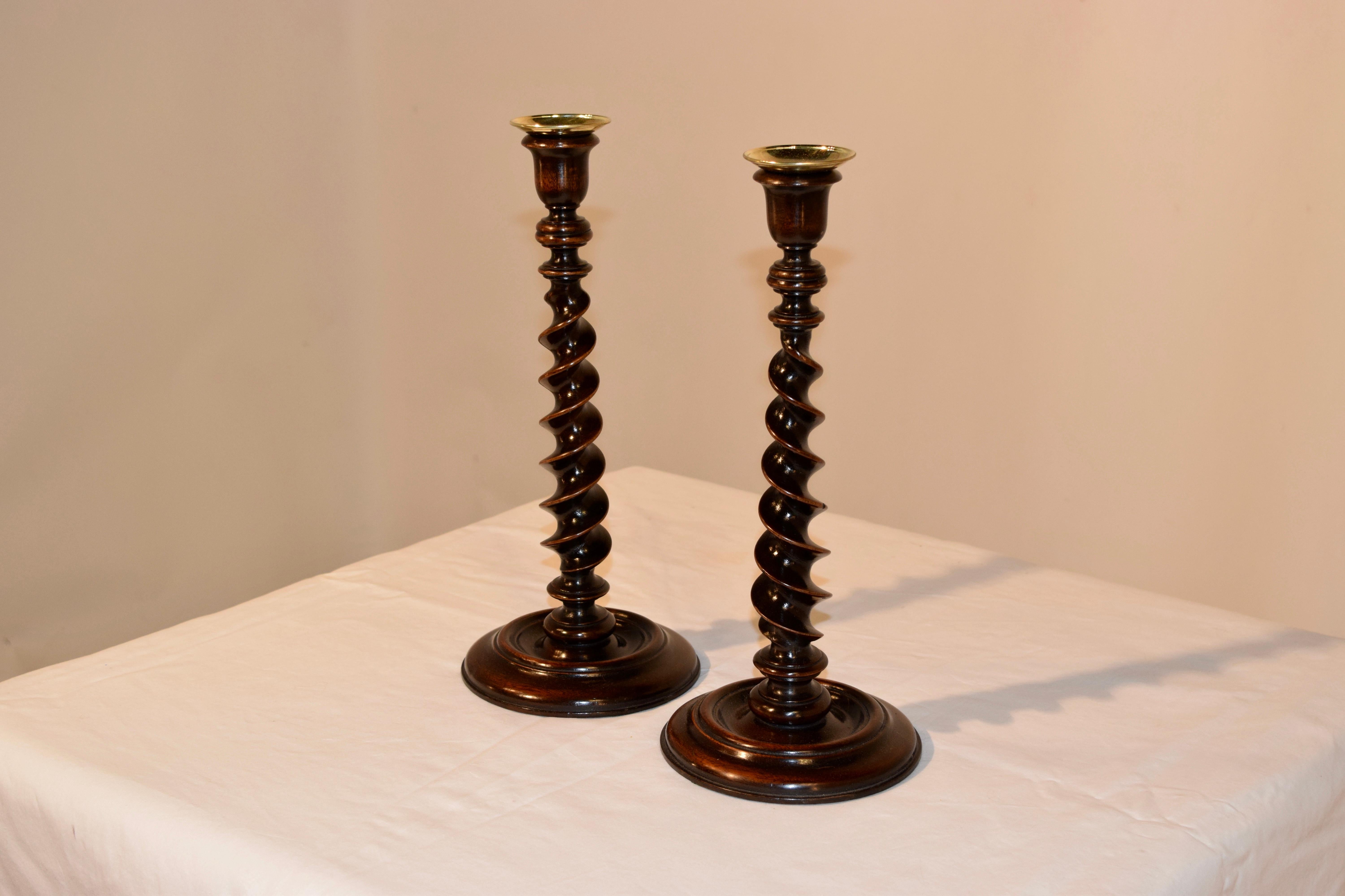 Very unusual pair of 19th century oak candlesticks made from mahogany. The candle cups are hand-turned in a tulip shape and are supported on wonderfully hand-turned ribbon twist stems and hand-turned bases. Ribbon twist is a very unusual and Fine