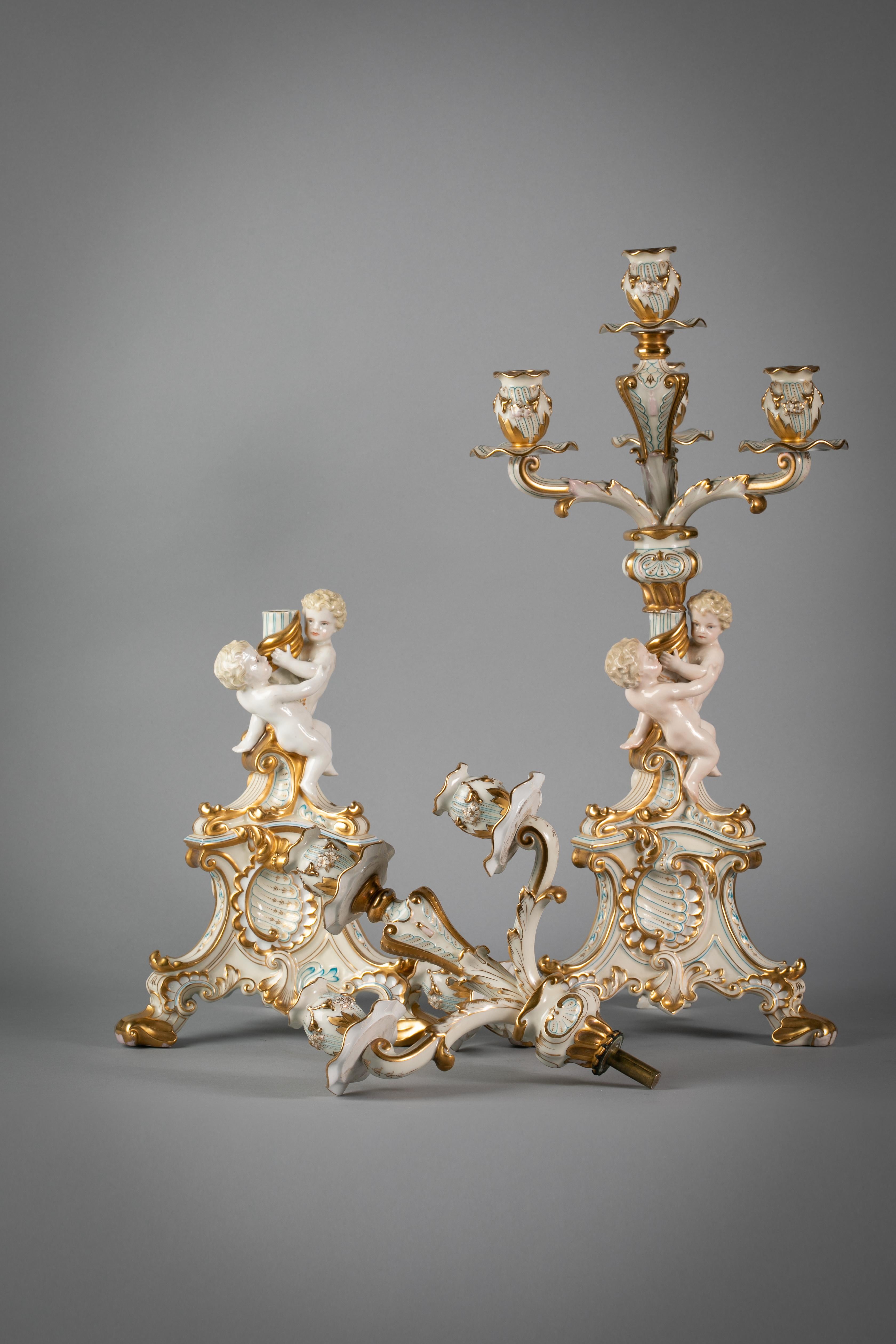 Each four-light candelabrum branch supported by a pair of putti on a triangular Rococo base molded with shell motifs. Marked Pirkenhamer.