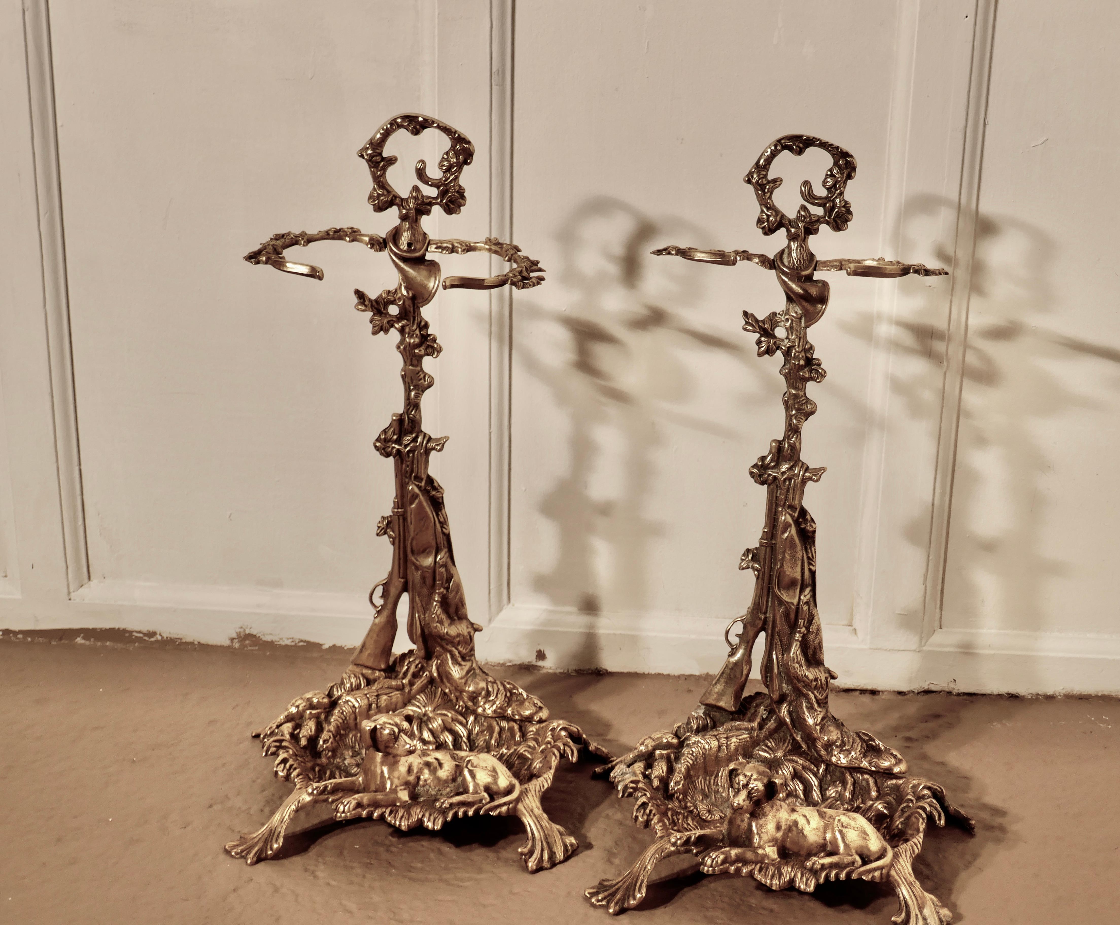 Pair of unusual French hunting theme (Chasse) brass stick stands

These lovely pieces come from France, they are in the Chasse style and decorated with hunting dogs, guns, horns, all the trappings needed for the hunt
Both stands are in excellent