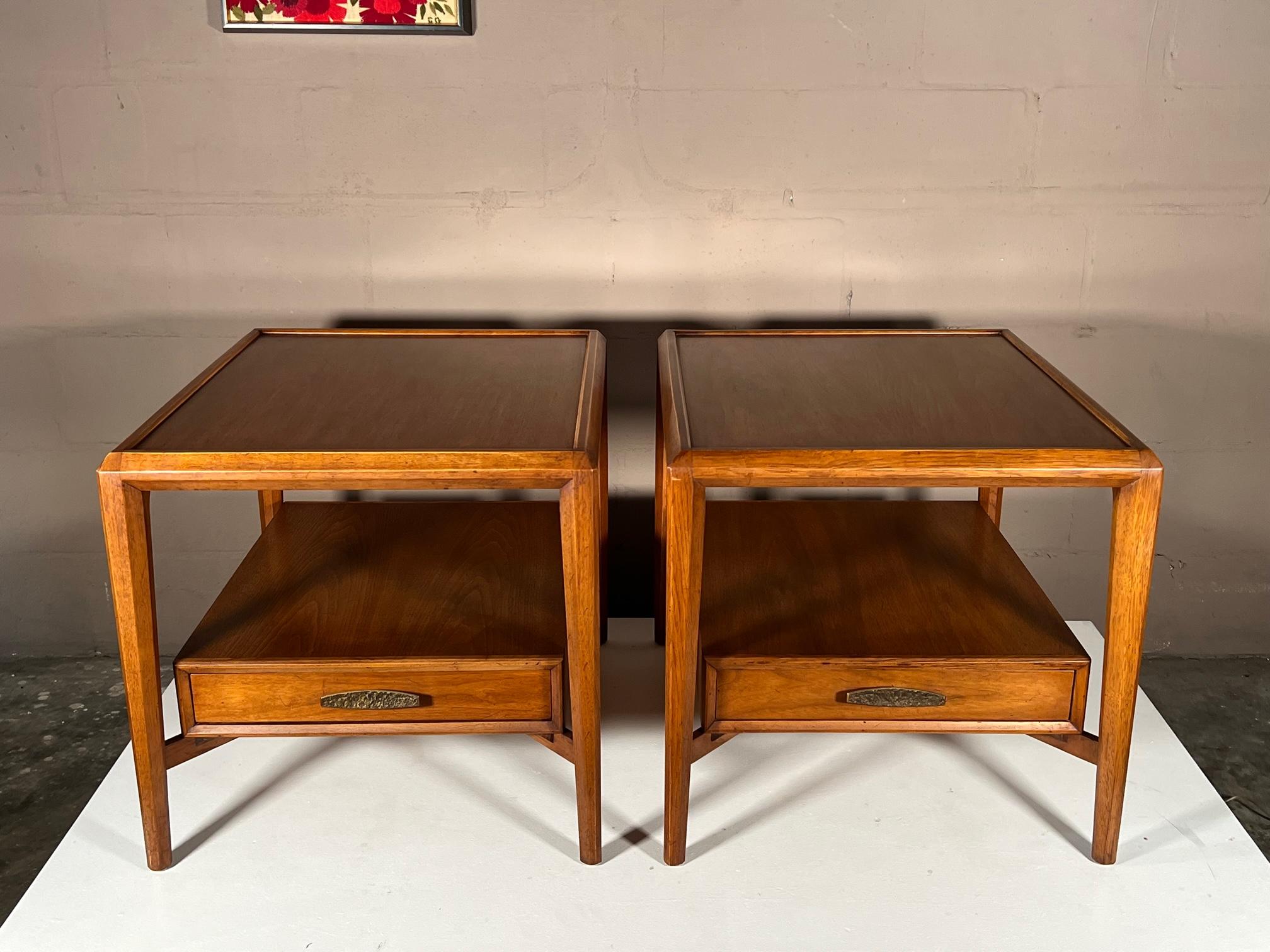 A pair of unusual Heritage Henredon nightstands. Walnut with brass details and beautiful travertine tops. Walnut frames have a nice patina. Asian style hardware in solid, heavy brass.
