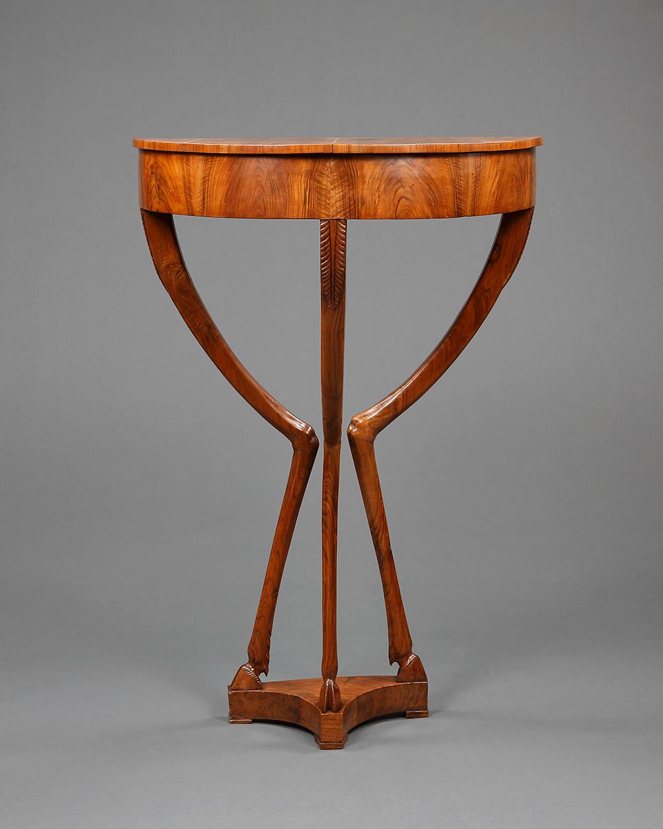 A pair of unusual early 19th century Italian demilune side tables veneered in walnut with tapering zoomorphic legs terminating in hoofed feet above a triangular pedestal.

Italian, circa 1820.