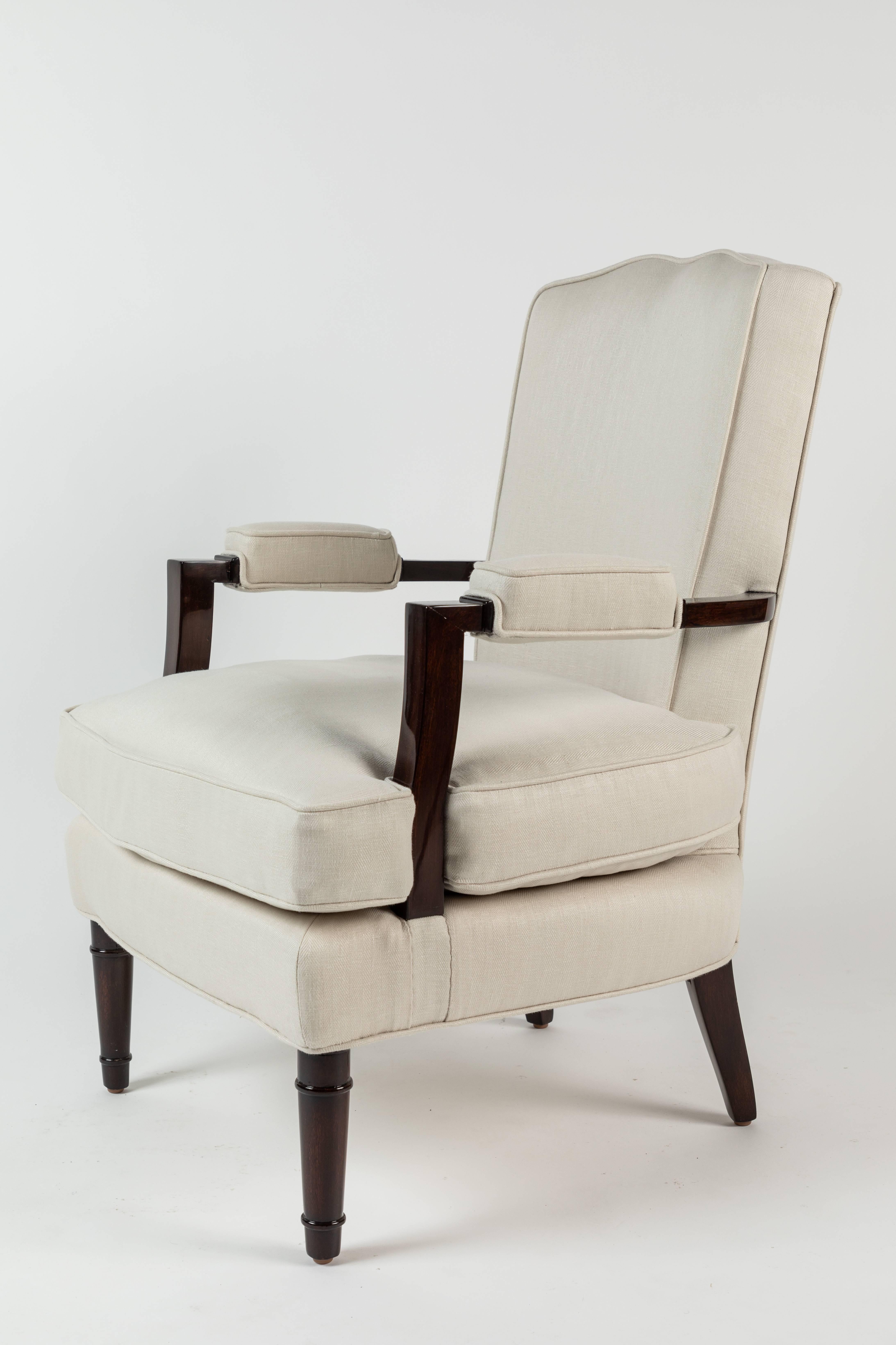 This stylish pair of armchairs designed by legendary designer and decorator Jules Leleu Reaganism their model number (25) 059 to the inside of the rear leg. Beautiful polished walnut frames and new Holland and Sherry linen upholstery, these chairs