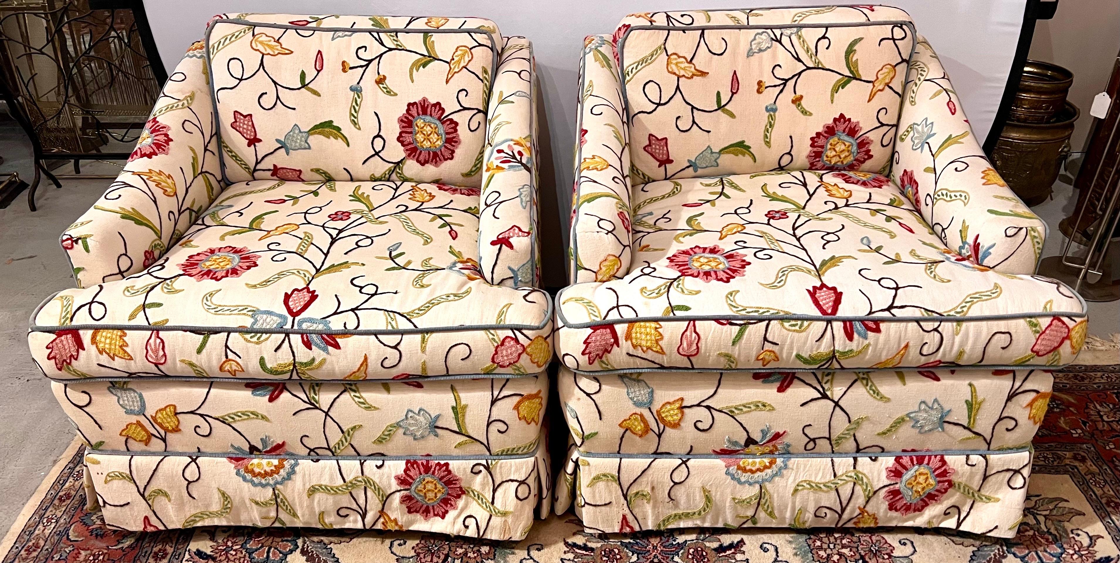 Pair of club chairs upholstered in beautiful Chinoiserie style floral crewel work with blue piping.
Loose seat and back cushion. On castors for ease of movement.