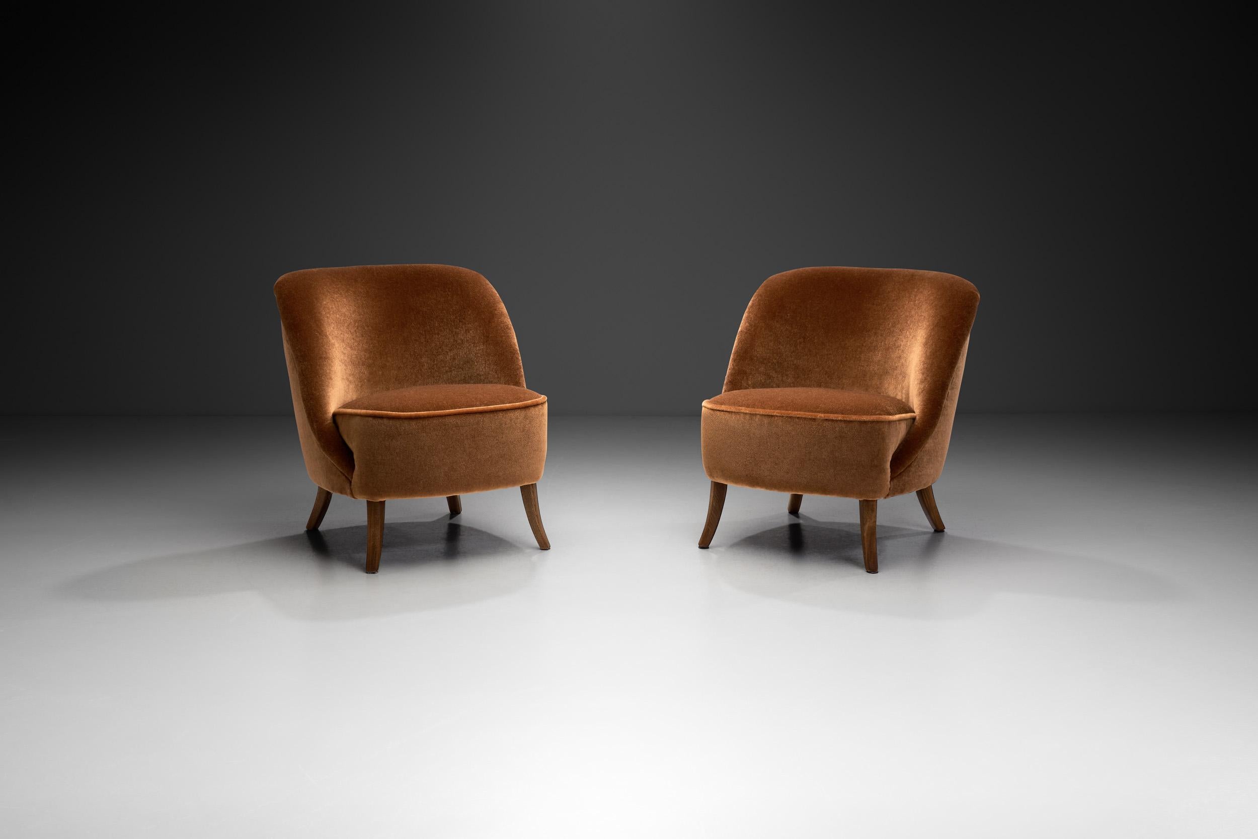 Cette étonnante paire de chaises de salon cocktail s'articule autour de l'utilisation de matériaux de haute qualité, du confort et de la maîtrise des ébénistes européens de l'époque. Le design/One est axé sur l'esthétique du modernisme, tout en