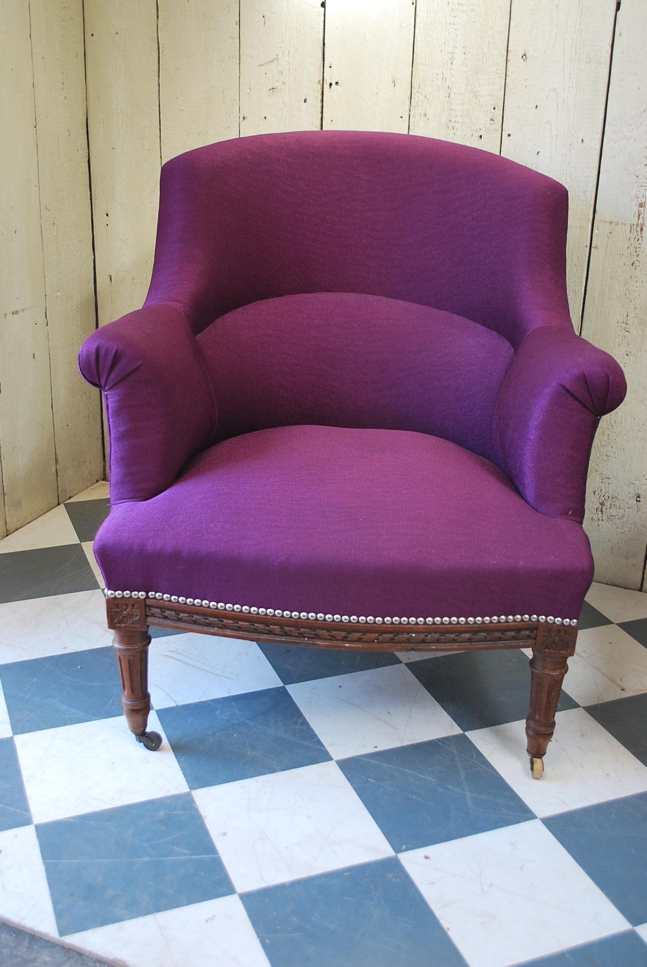 A good quality pair of Napoleon III French Fauteuil armchairs, recently upholstered in purple fabric. Standing on fluted turned legs, with a carved frieze along the bottom with rosettes. Both sturdy and very comfortable. Extremely well upholstered