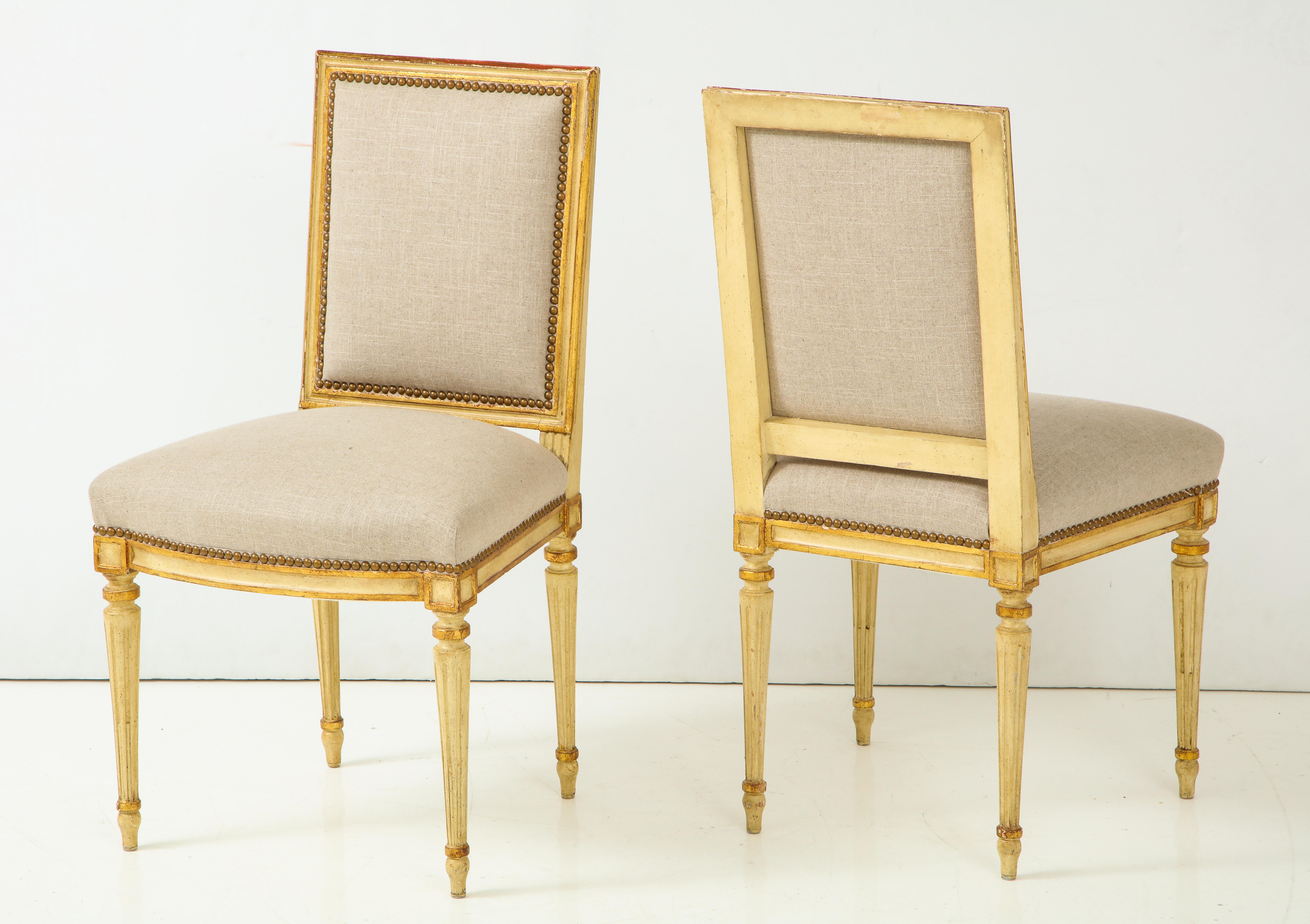 An exceptional pair of side chairs in the Louis XVI style. The chairs feature the reeded, tapered legs characteristic of this style. The painted finish is accented in gold leaf, making for a warm, rich patina. Perfect as pull-up chairs or on either