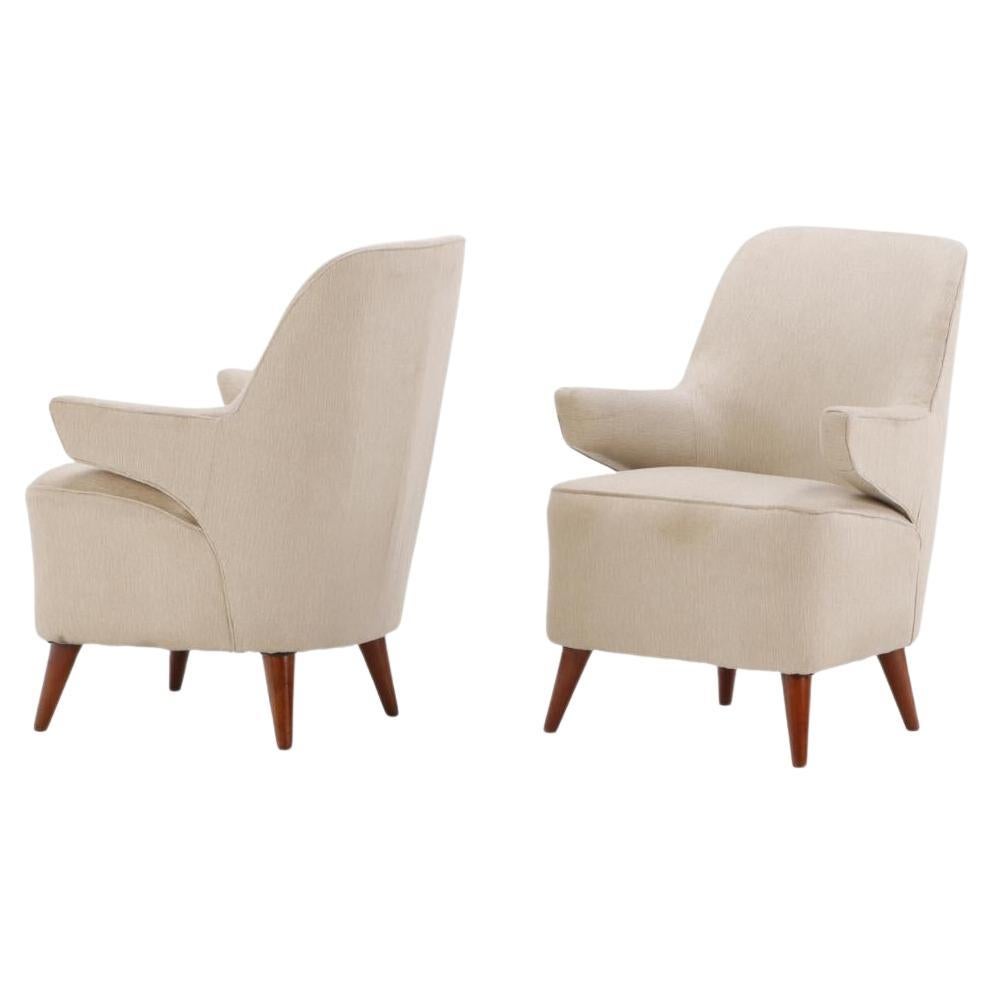 Pair of upholstered lounge chairs circa 1950 having floating arms and new fabric For Sale