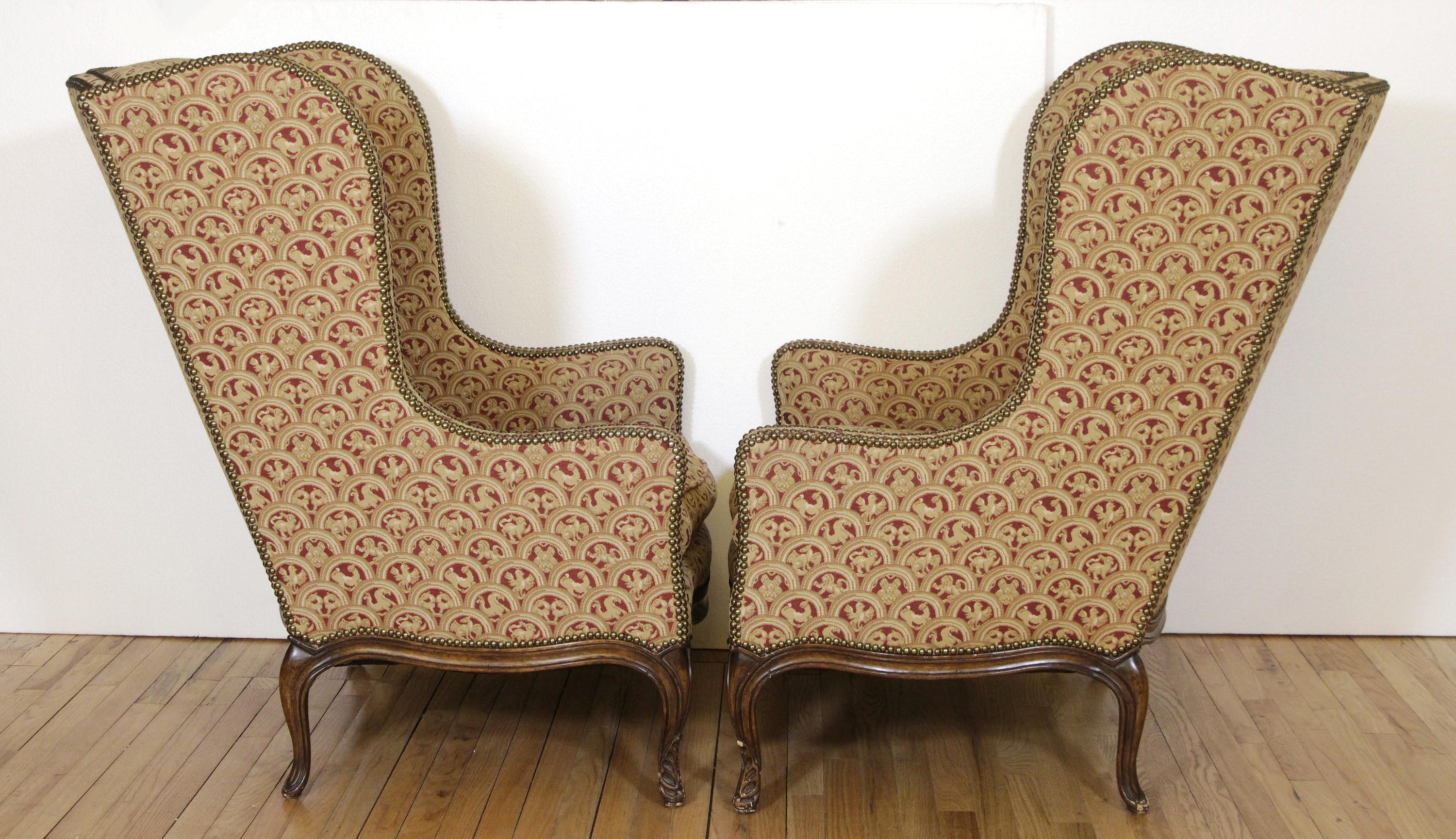 American Pair of Upholstered Tan Wing Back Chairs w/ Ornate Figural Details