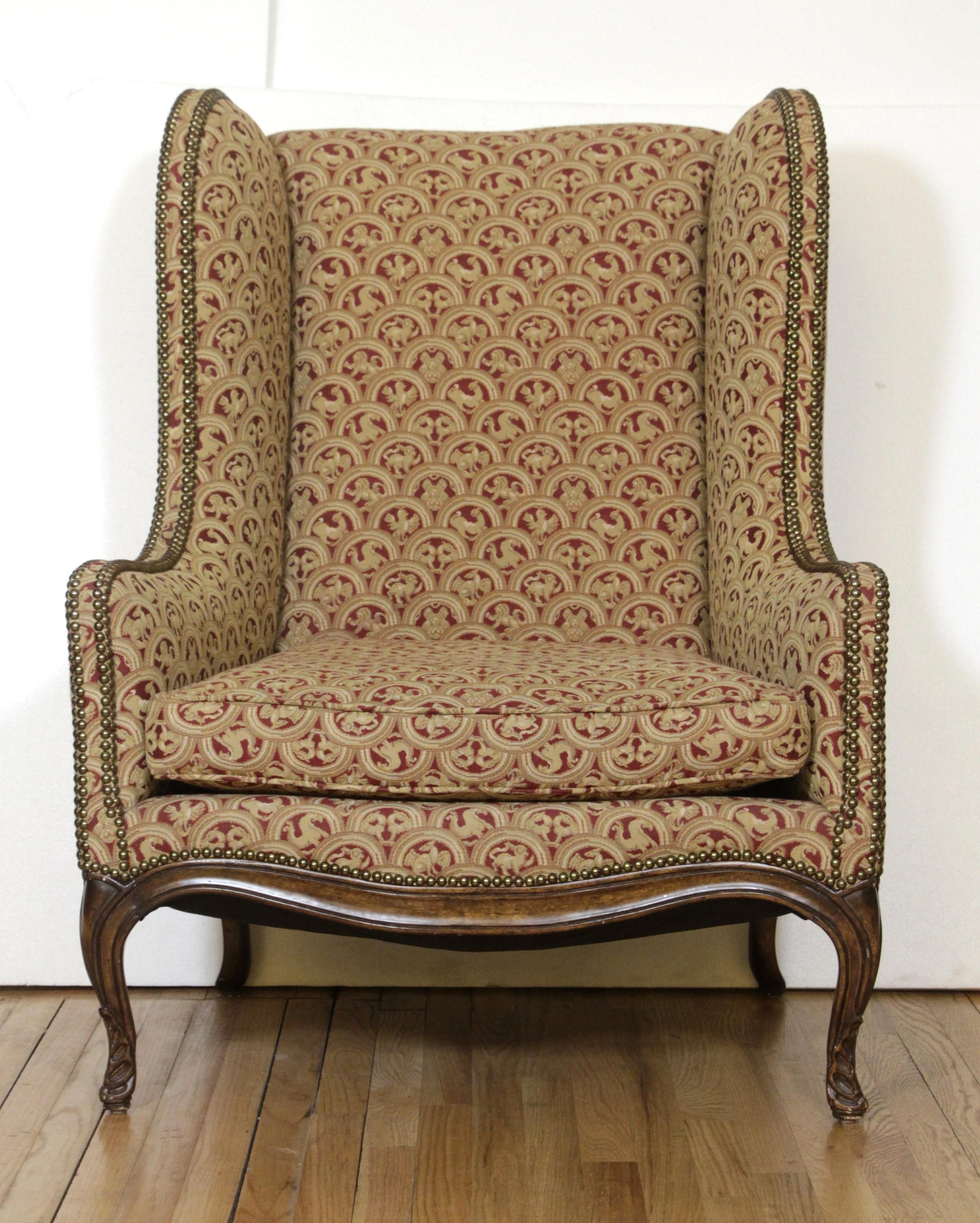20th Century Pair of Upholstered Tan Wing Back Chairs w/ Ornate Figural Details
