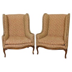 Pair of Upholstered Tan Wing Back Chairs w/ Ornate Figural Details