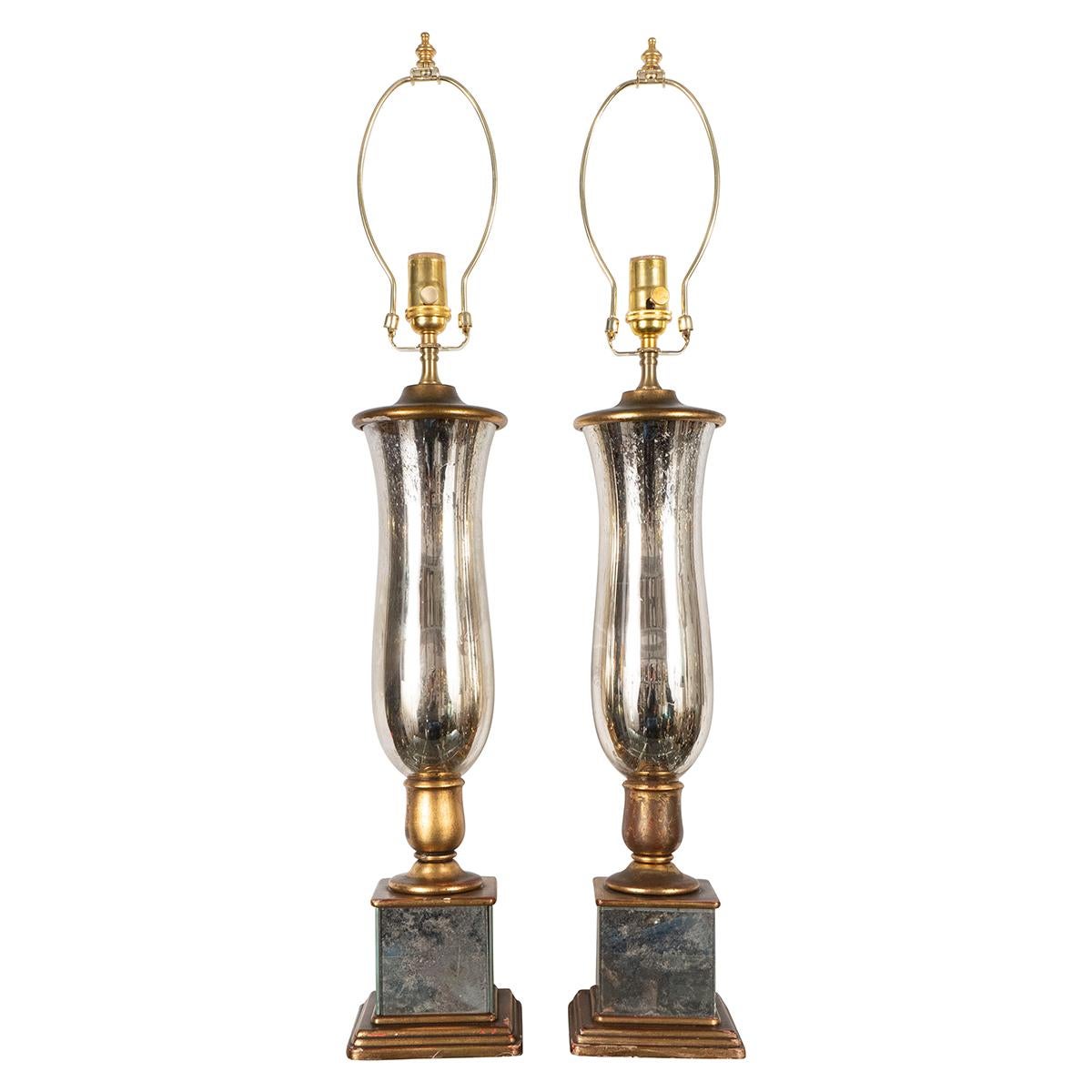 Pair of urn-shaped mercury glass lamps on mirror plinth bases.