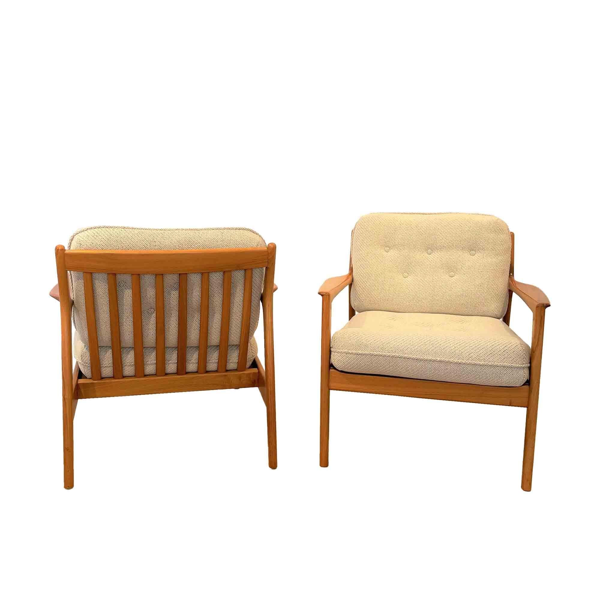 Pair of USA 75 model armchairs in walnut by Swedish designer Folke Ohlsson. The design of these armchairs is distinguished by a very taut line of the armrests and the rear legs with a beautiful grain of the walnut on the sides. The back of these