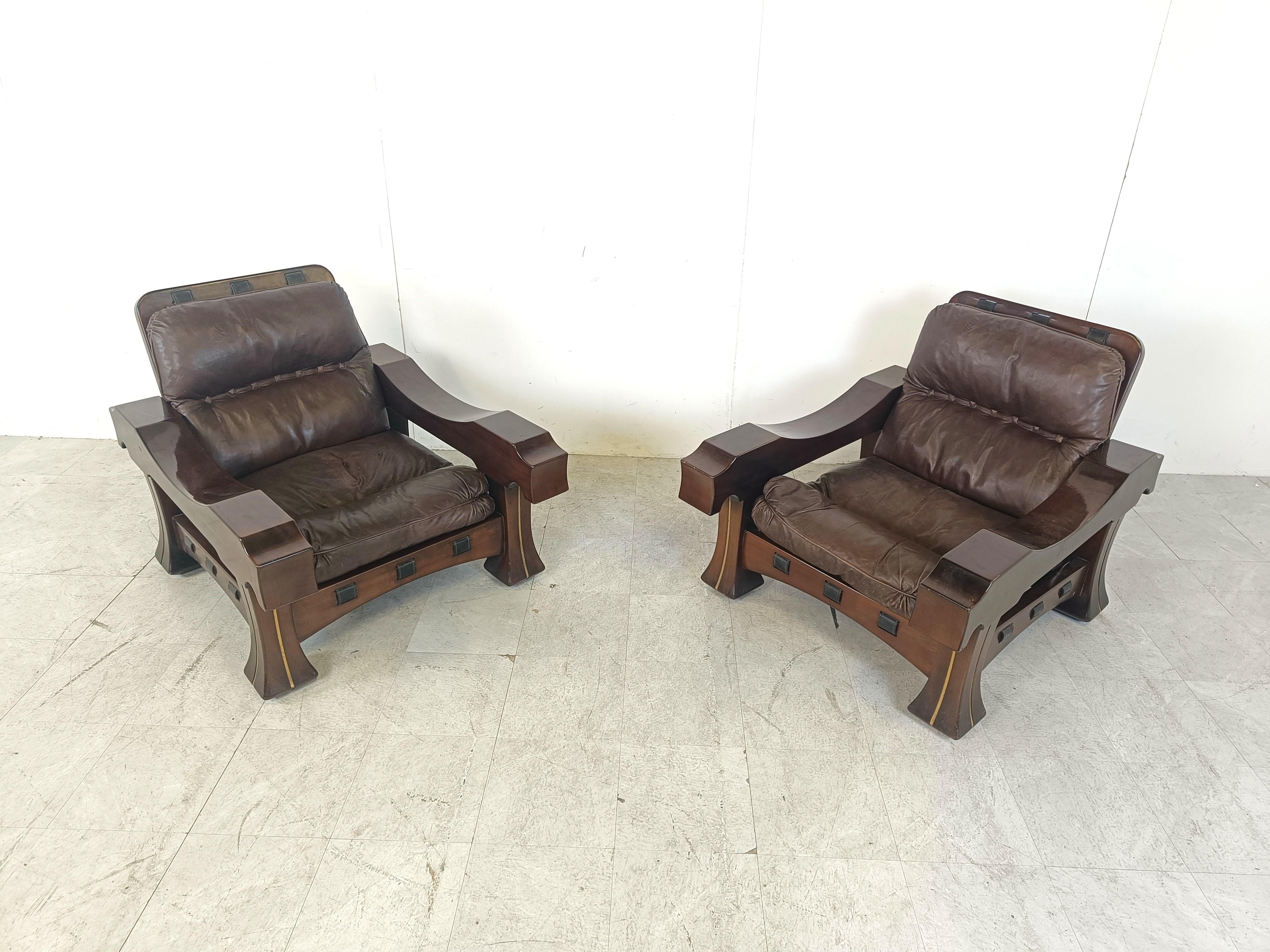 Zwei robuste Sessel aus der Mitte des Jahrhunderts Modell Ussaro - entworfen von Luciano Frigerio.

Diese schweren und sehr stabilen Holzsessel haben ein sehr brutales und solides Design, man kann sie nicht übersehen.

Sie sind mit Lederkissen und