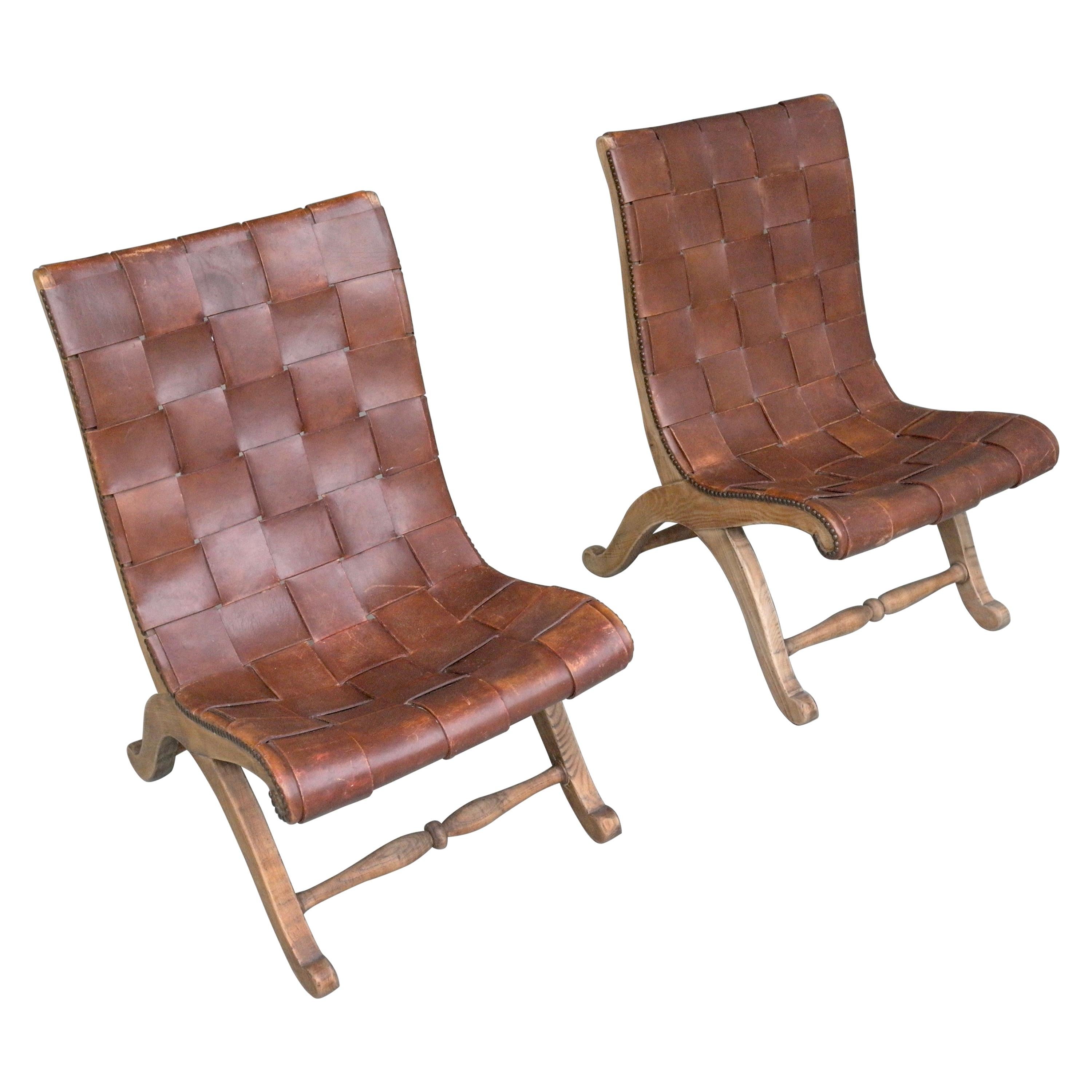Pair of Valenti Spanish leather armchairs attributed to Pierre Lottier made circa 1950s. Curved Oak frame with brass nailhead details and original Cognac strap leather with lovely Patina. 

Pierre Lottier was born in France before moving to Spain