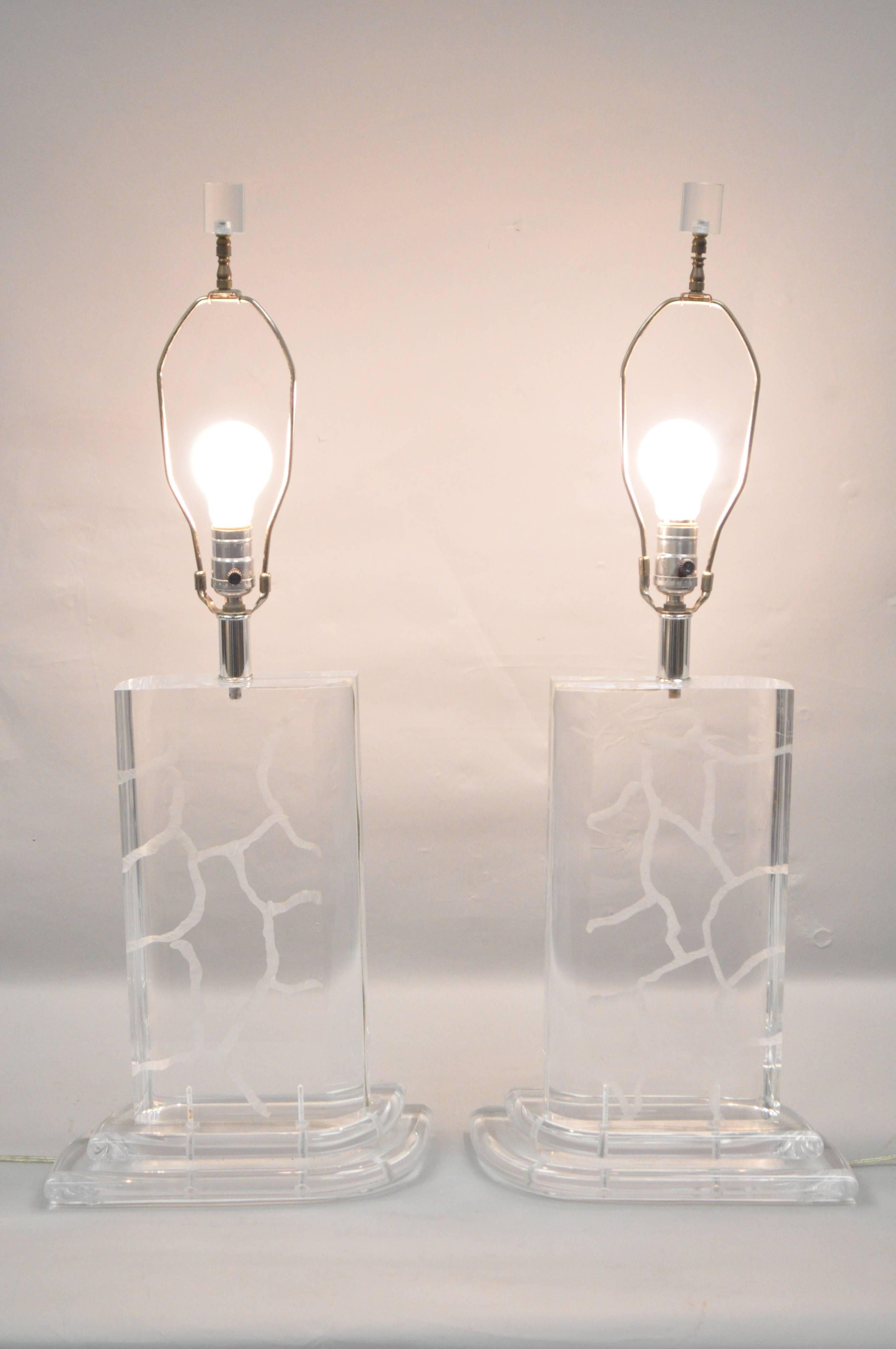 Pair of Van Teal Mid-Century Modern or Hollywood Regency clear etch decorated Lucite table lamps. Item features solid clear Lucite forms with wave or crackle etched design topped off with Lucite finials. Designed By Hivo Van Teal.
Measurements: 32