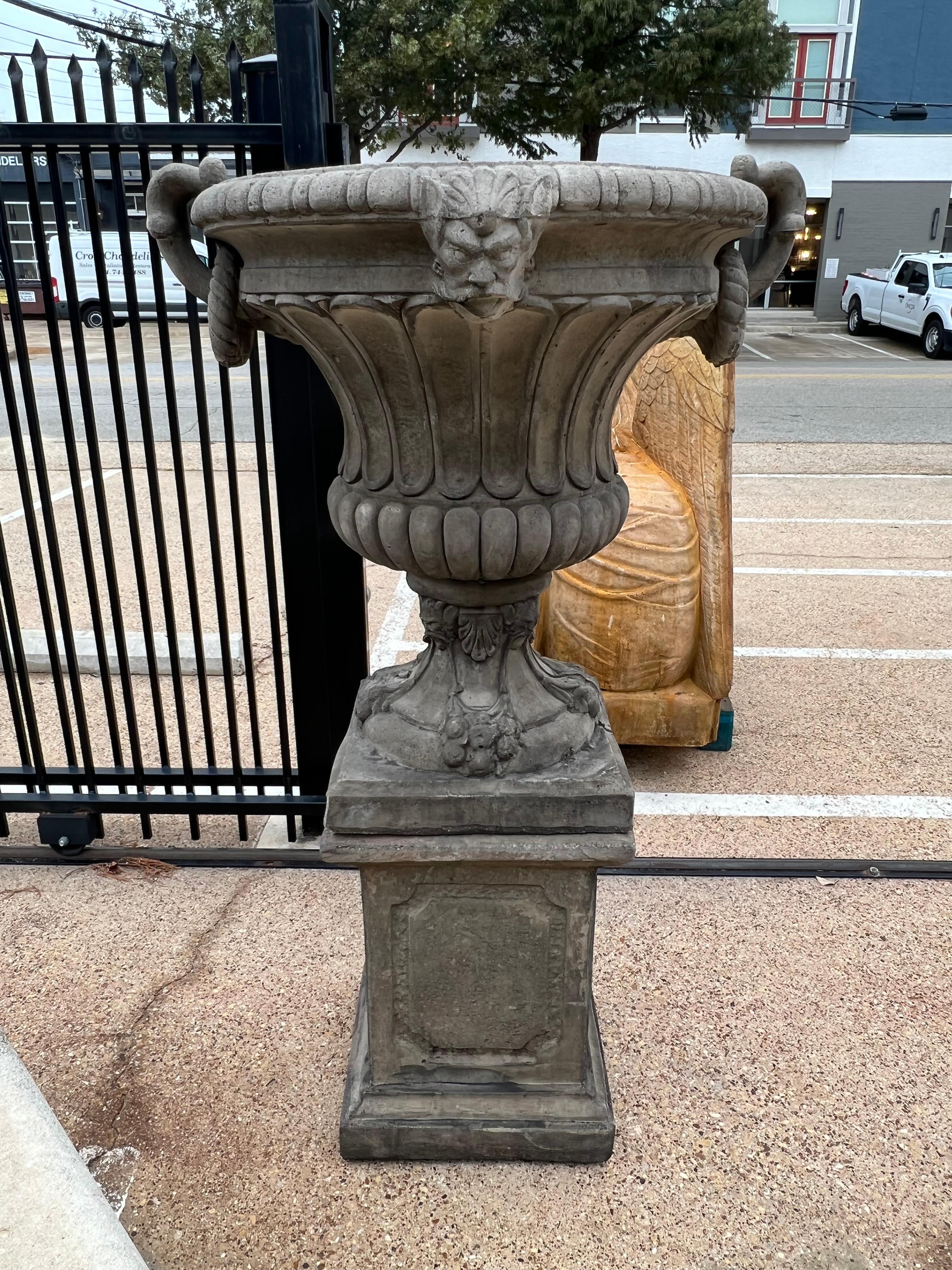 These large cast vases on pedestals from France would look wonderful flanking the entrance of a drive or standing at the corners of a pool.  The detailed vases are decorated with repeating patterns of gadrooning, mascarons, and pronounced handles