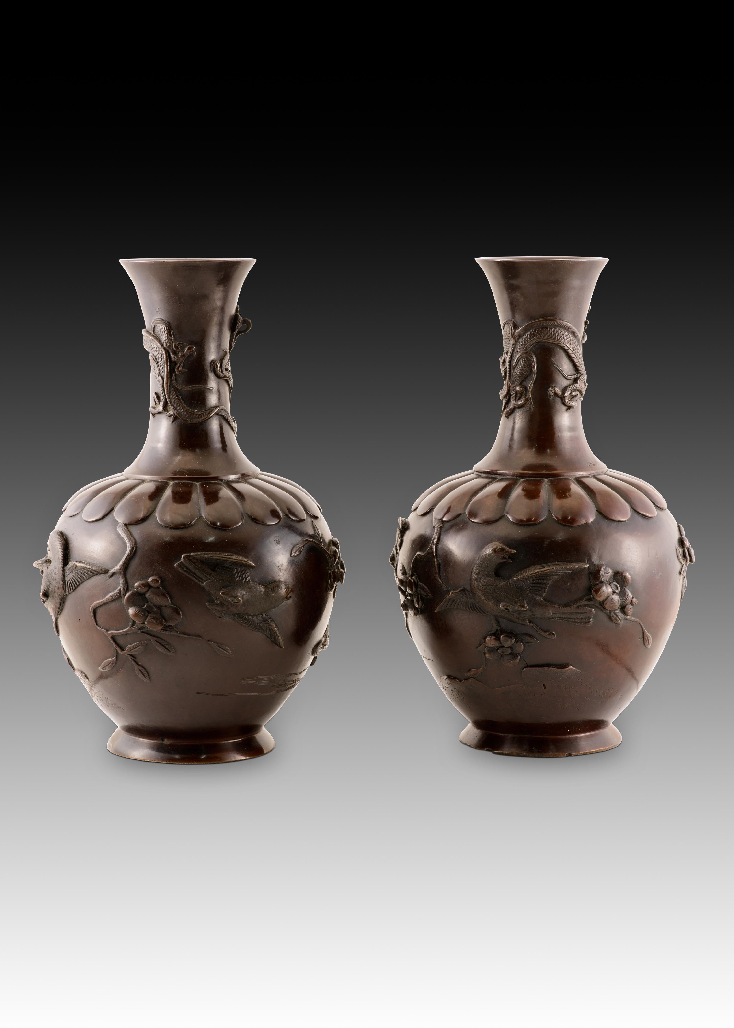 Pair of vases. Bronze. Japan, Meiji period (1868 1912). 
Pair of bronze vases decorated with figurative elements and a band of gadroons. The necks feature two oriental-style dragons in flight, while the bodies depict birds, branches, and fruit in