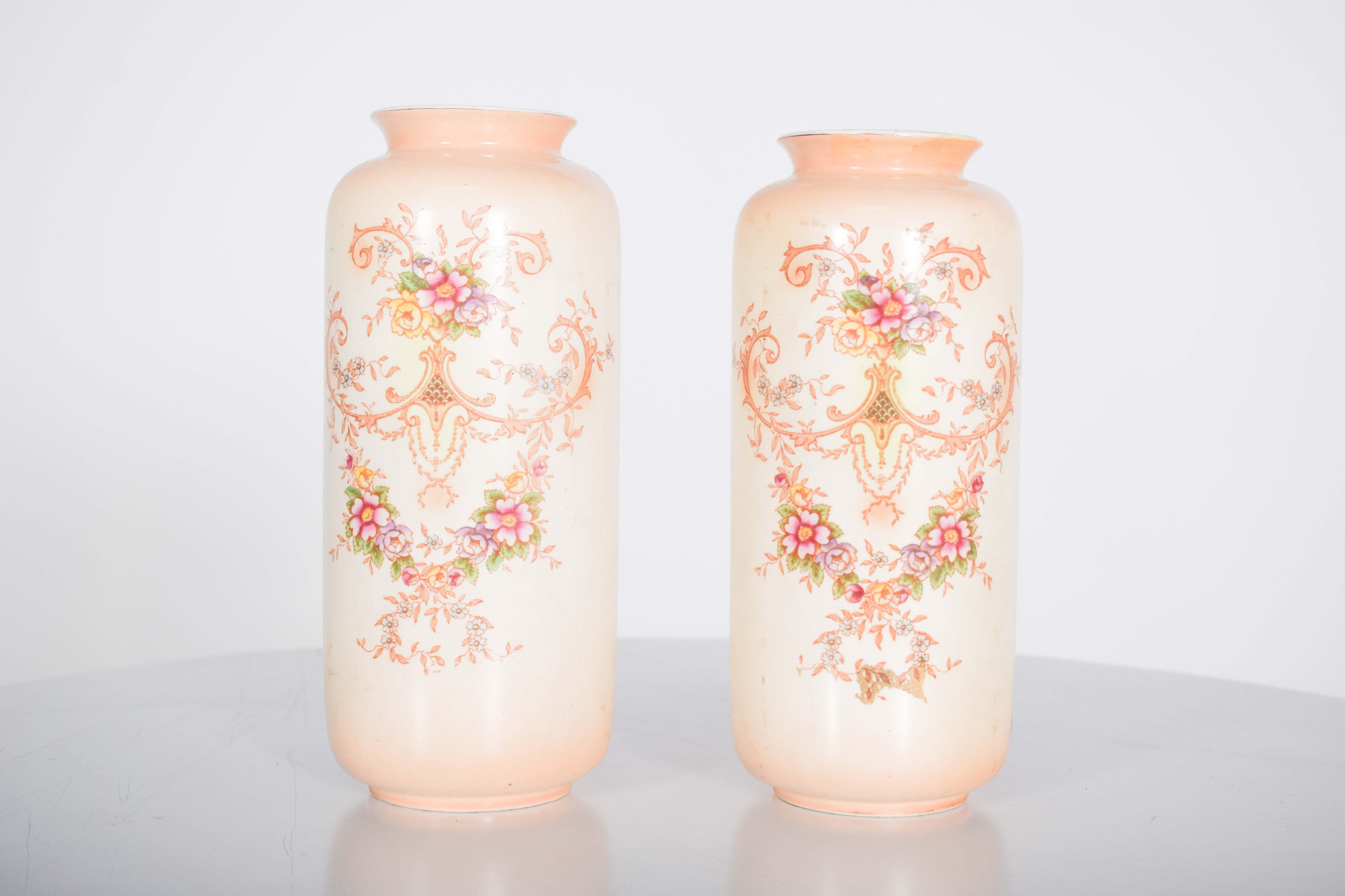 Paire de vases, en céramique anglaise. Décoration polychrome, présentant une combinaison exubérante de fleurs et de guirlandes délicates, magistralement peintes dans des couleurs douces. Les fleurs sont minutieusement détaillées, avec des pétales