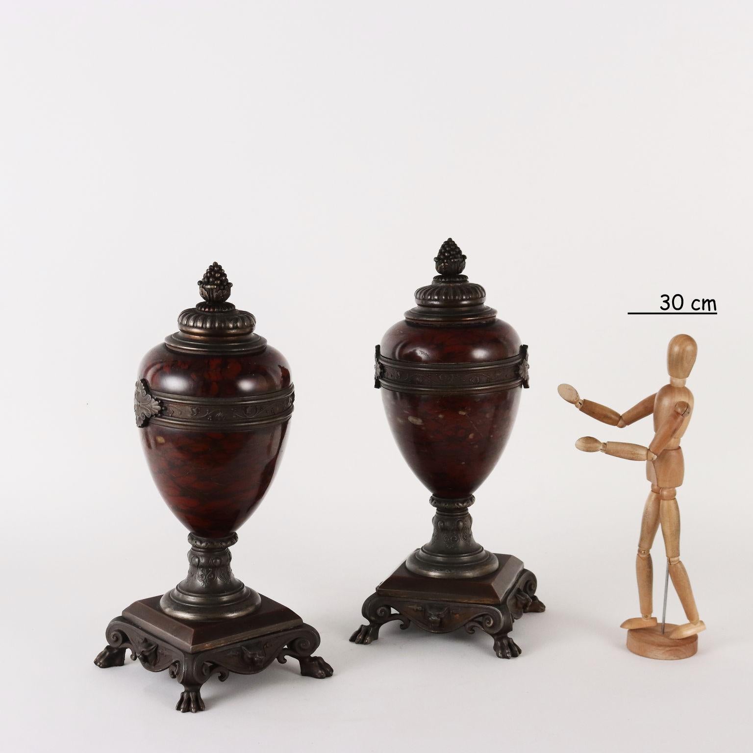 Paar Vasen aus Rouge Griotte-Marmor, montiert auf bronzefarbenem, patiniertem Metall. Verzierungen mit pflanzlichen und zoomorphen Motiven; Füße in Form von Wildtieren.