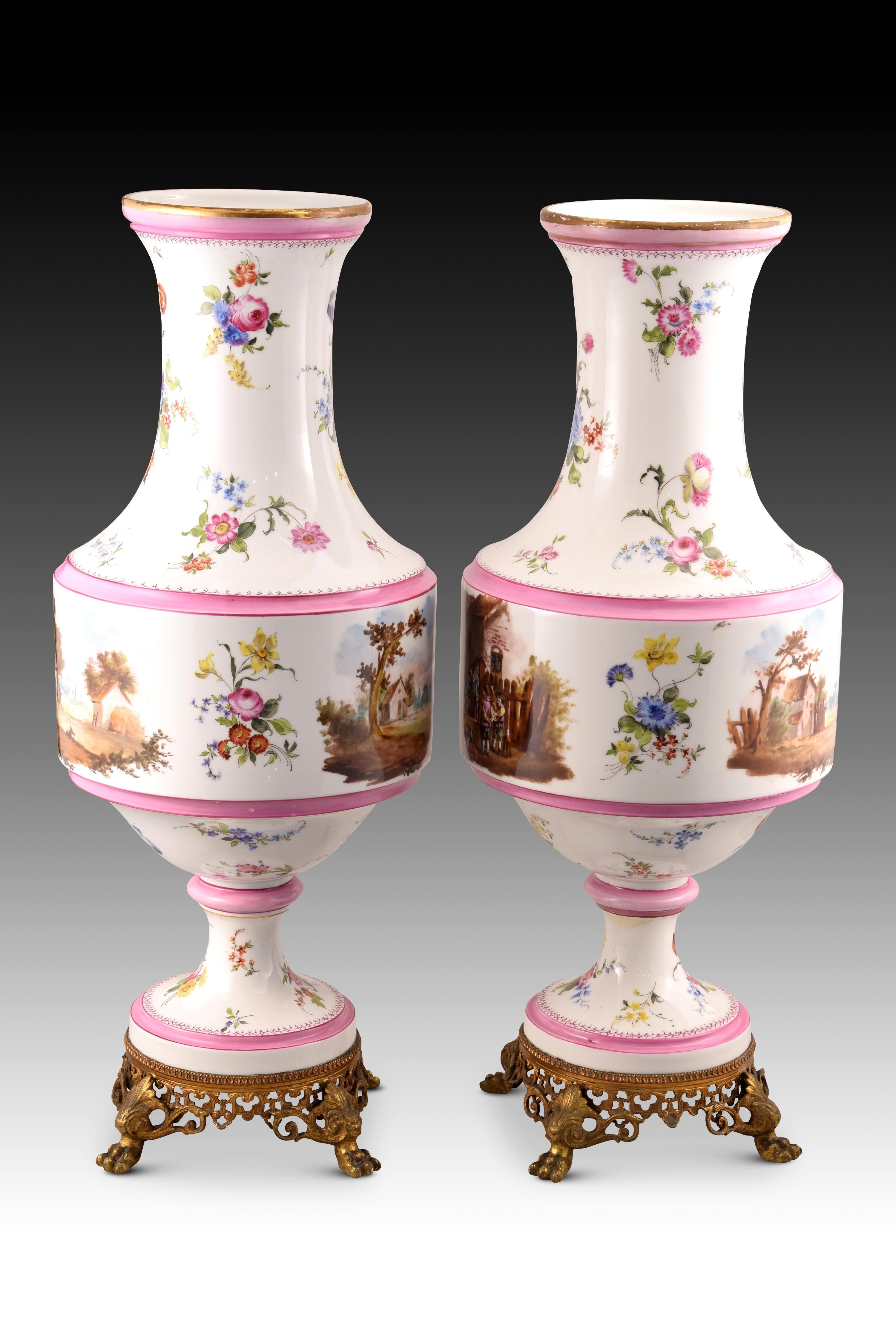 Pair of vases. Glazed porcelain, metal. XIX century. 
Pair of vases with a circular foot, a cylindrical body in the center and a long neck and mouth open towards the outside, decorated with bands in a pink tone, golden edges, grouped flowers and