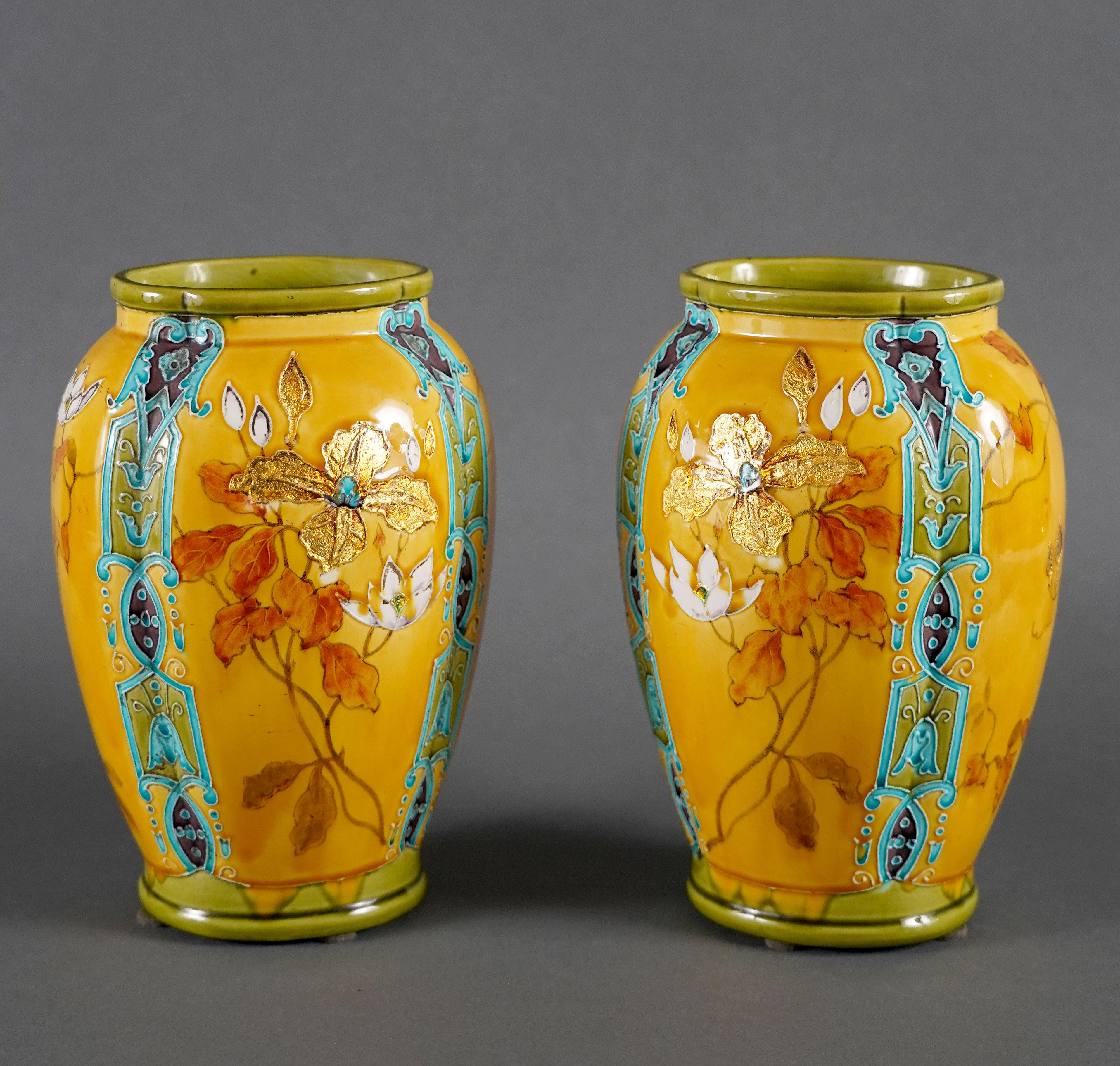 
Charmante paire de vases en faïence polychrome avec entrelacs de feuilles d'or, technique dont Théodore Deck s'était fait une spécialité.
Ces vases de forme oblongue sont décorés de chaque côté de bouquets d'iris et de cyclamens sur un fond