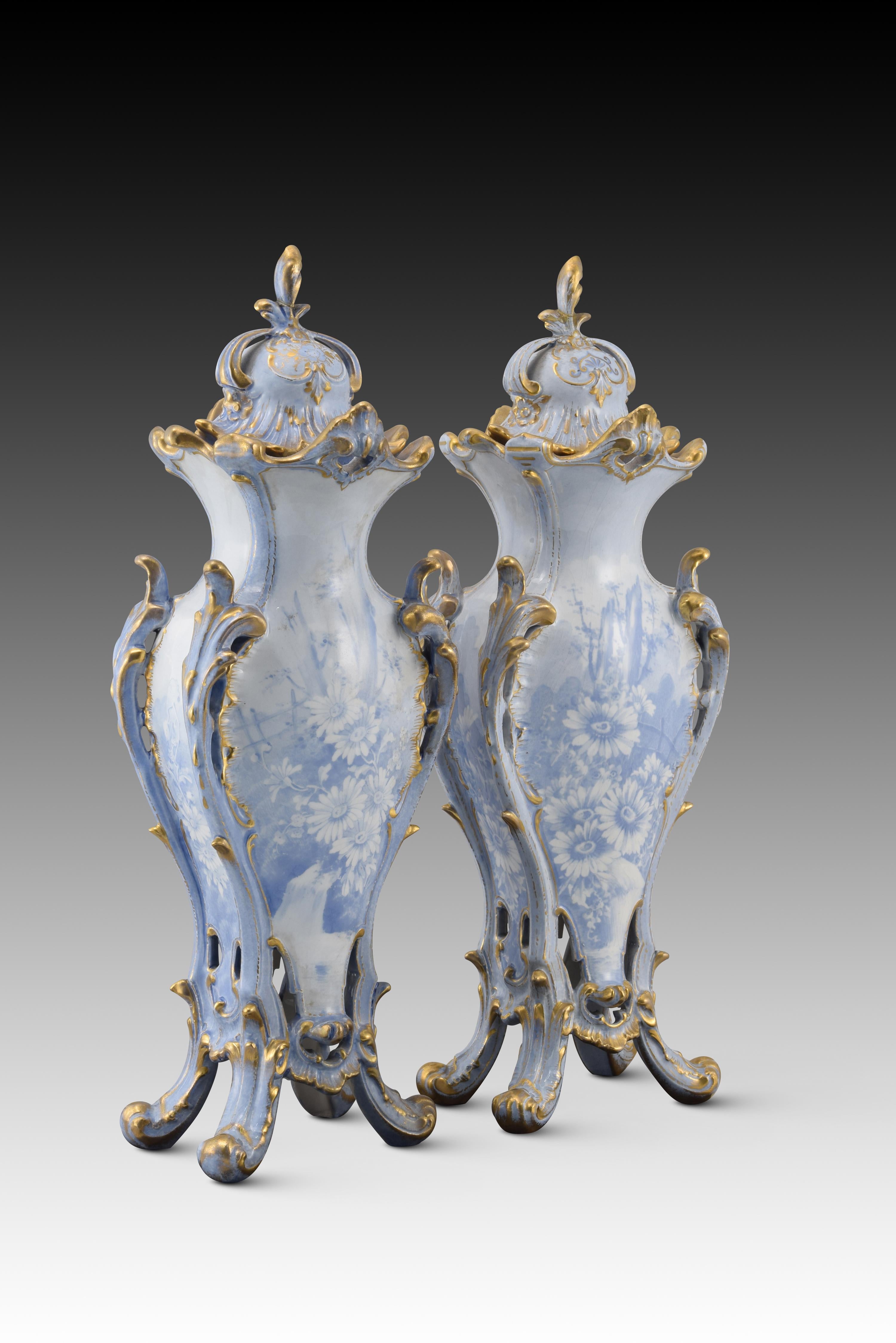 Pair of vases with lids. Enameled porcelain. Royal Bonn, Germany, around the beginning of the 20th century. 
They have faults. With marks on the bases. 
Pair of vases with four-legged bases in one piece that also have lids. They have been decorated