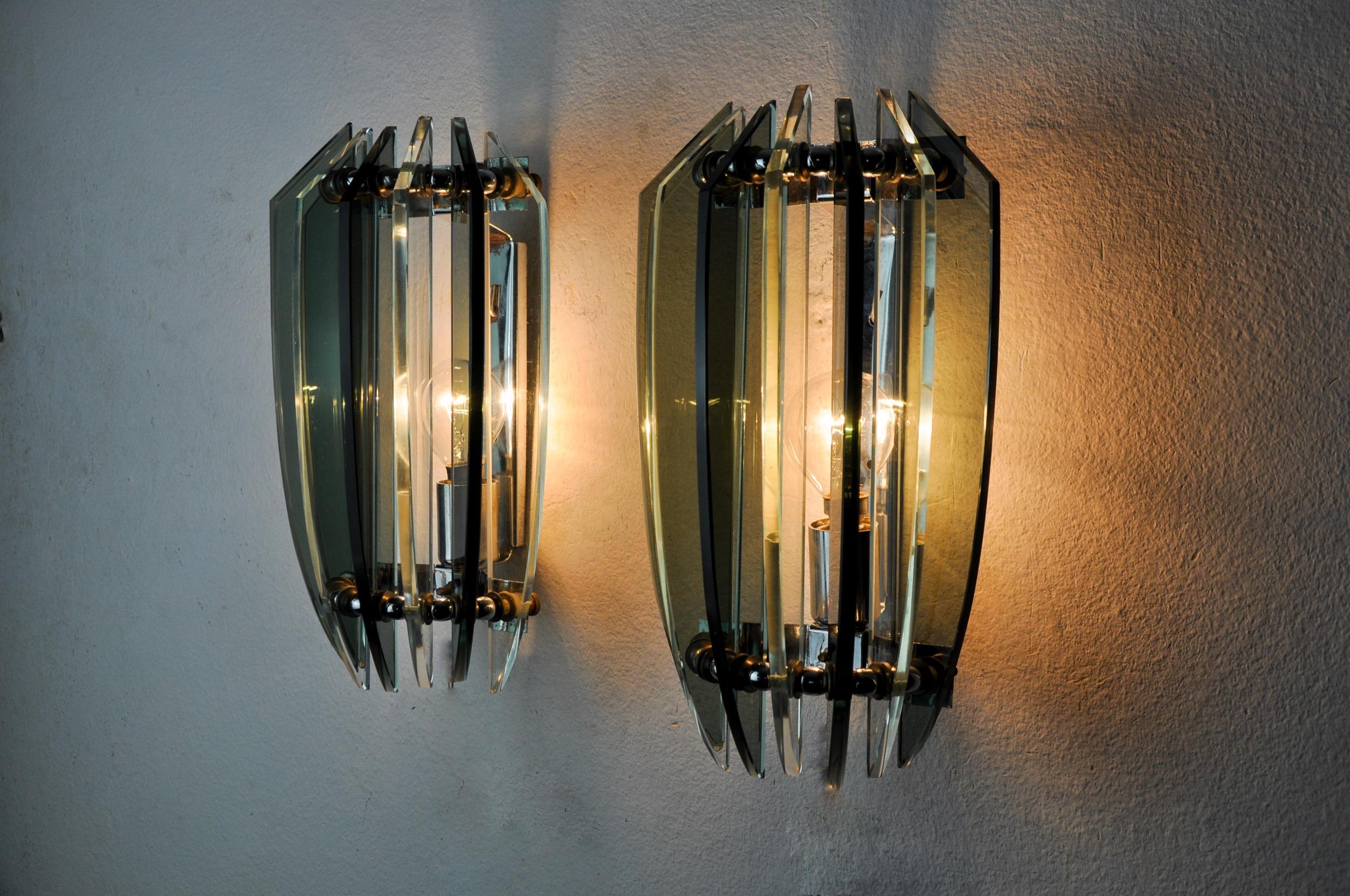 Superb and rare pair of two-tone veca wall lamps designated and produced in italy in the 70s. Wall lamps composed of green cut glass plates and a chromed metal structure. Unique object that will illuminate wonderfully and bring a real design touch
