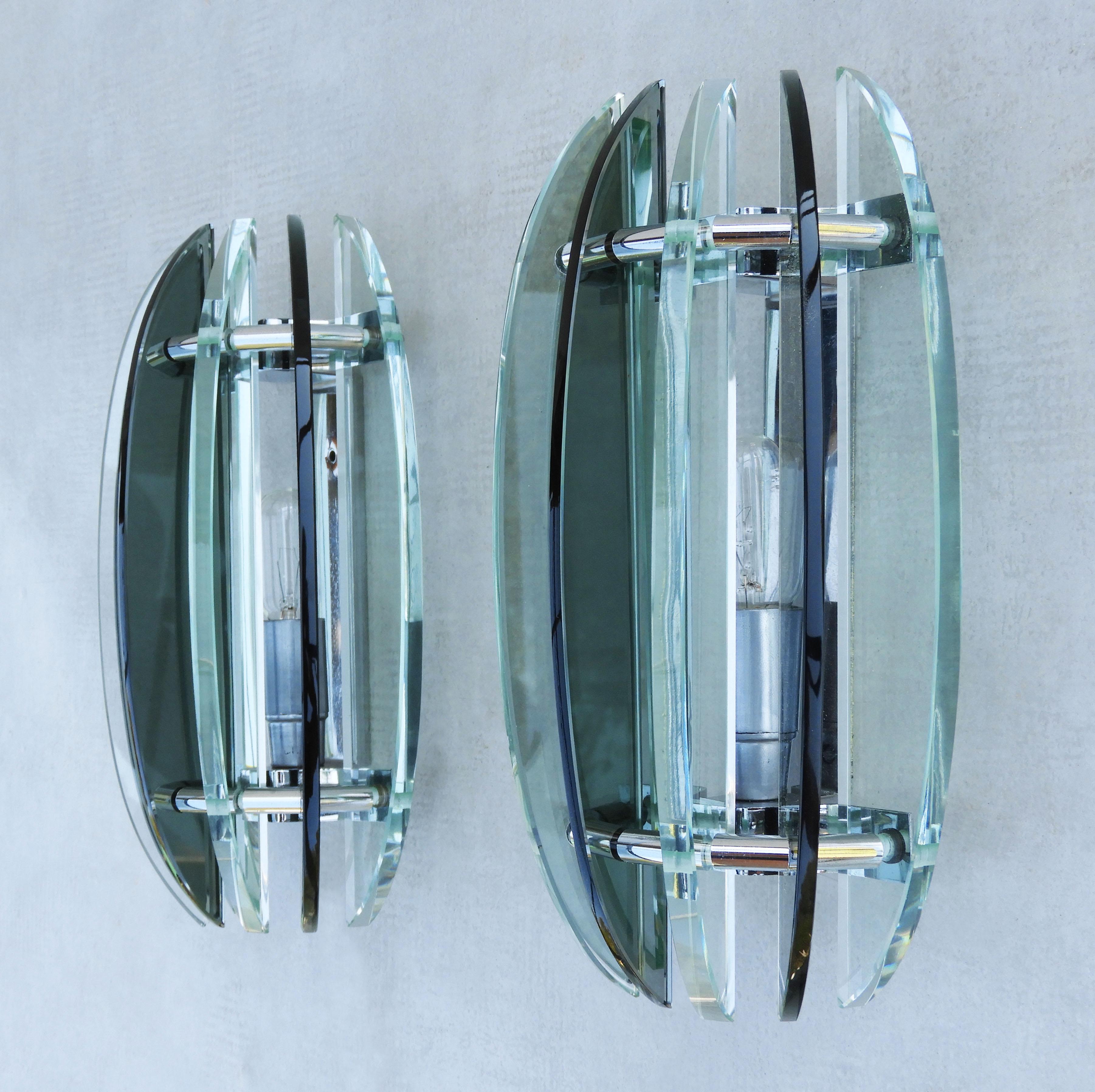 Pair of Veca glass wall lights mid century Italy, circa 1970

Two mid-century wall light sconces from Italian lighting company Veca.
Seven alternating crescents of smoked black and pale green glass in semicircular form on a chromed frame