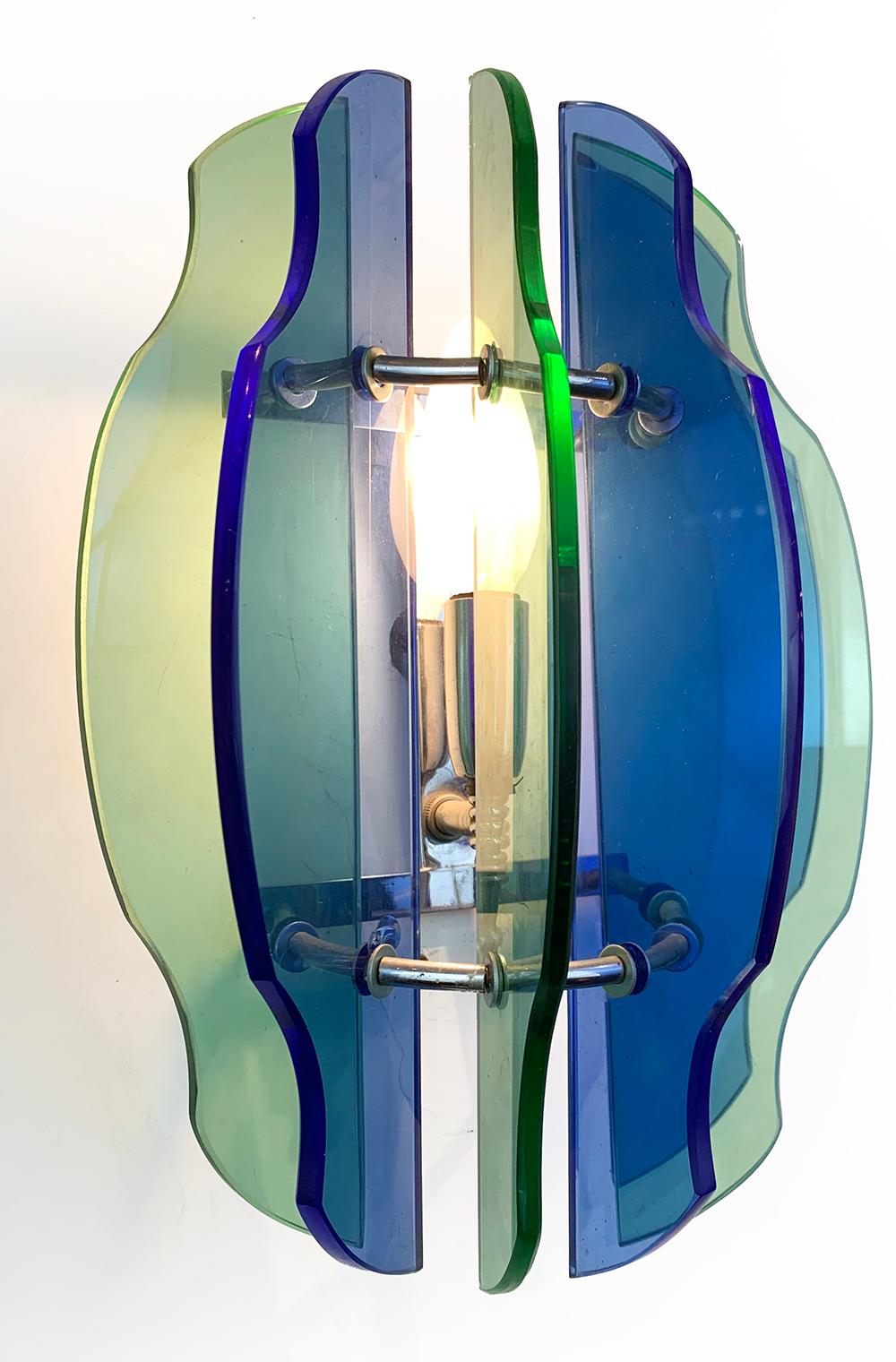 A pair of Mid-Century Modern sconces incorporating six blue and green glass panels that are attached to a small chromed metal frame. Each sconce has one candelabra socket and it can be wired for US or European use.
Veca was an Italian company