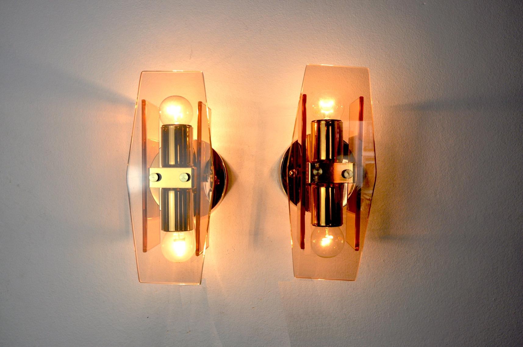 Very nice pair of Veca wall lamps produced in Italy in the 70s.

Wall lamps composed of pink cut glass plates and a golden structure.

Unique object that will illuminate perfectly and bring a real design touch to your interior.

Electricity