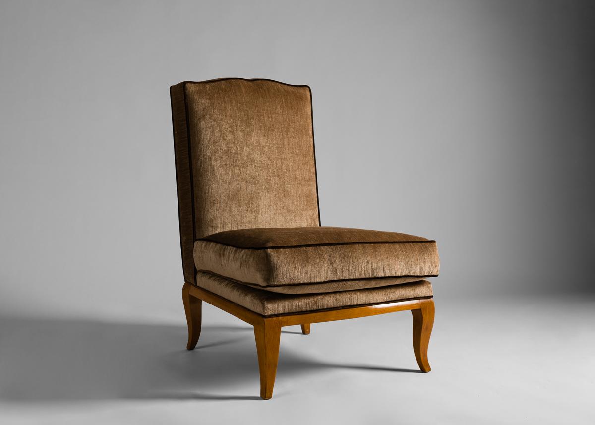 Cette paire de fauteuils pantoufles dans l'esthétique Art Déco, pelucheux et à haut dossier, est tapissée de velours avec un passepoil lavande.
  