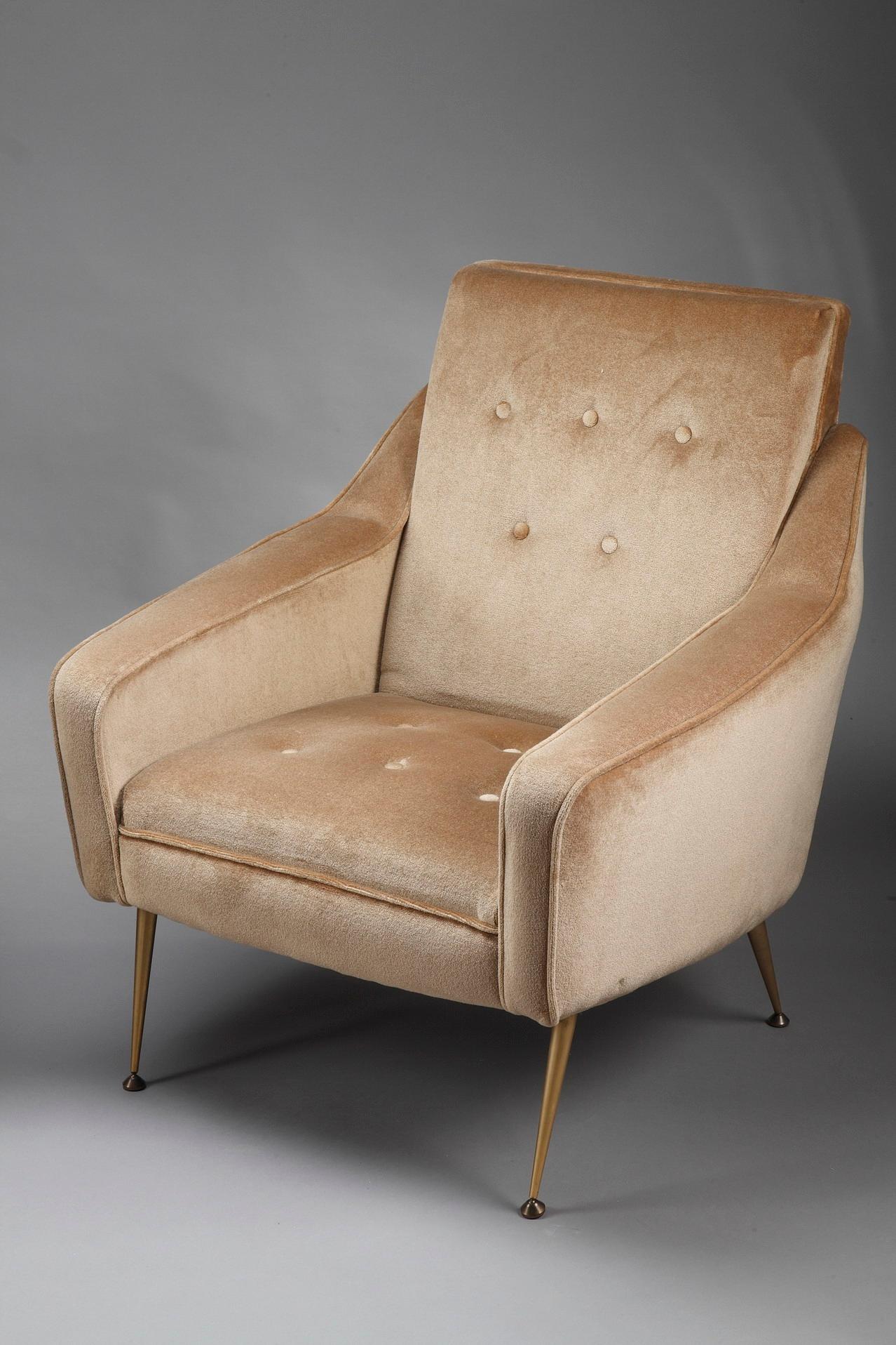Paire d'imposantes chaises bergère en velours ocre fabriquées dans les années 1950, avec pieds arqués en métal doré. La bergère est un grand fauteuil confortable dont les côtés solides montent jusqu'à la ceinture. Ce type de meuble est apparu en