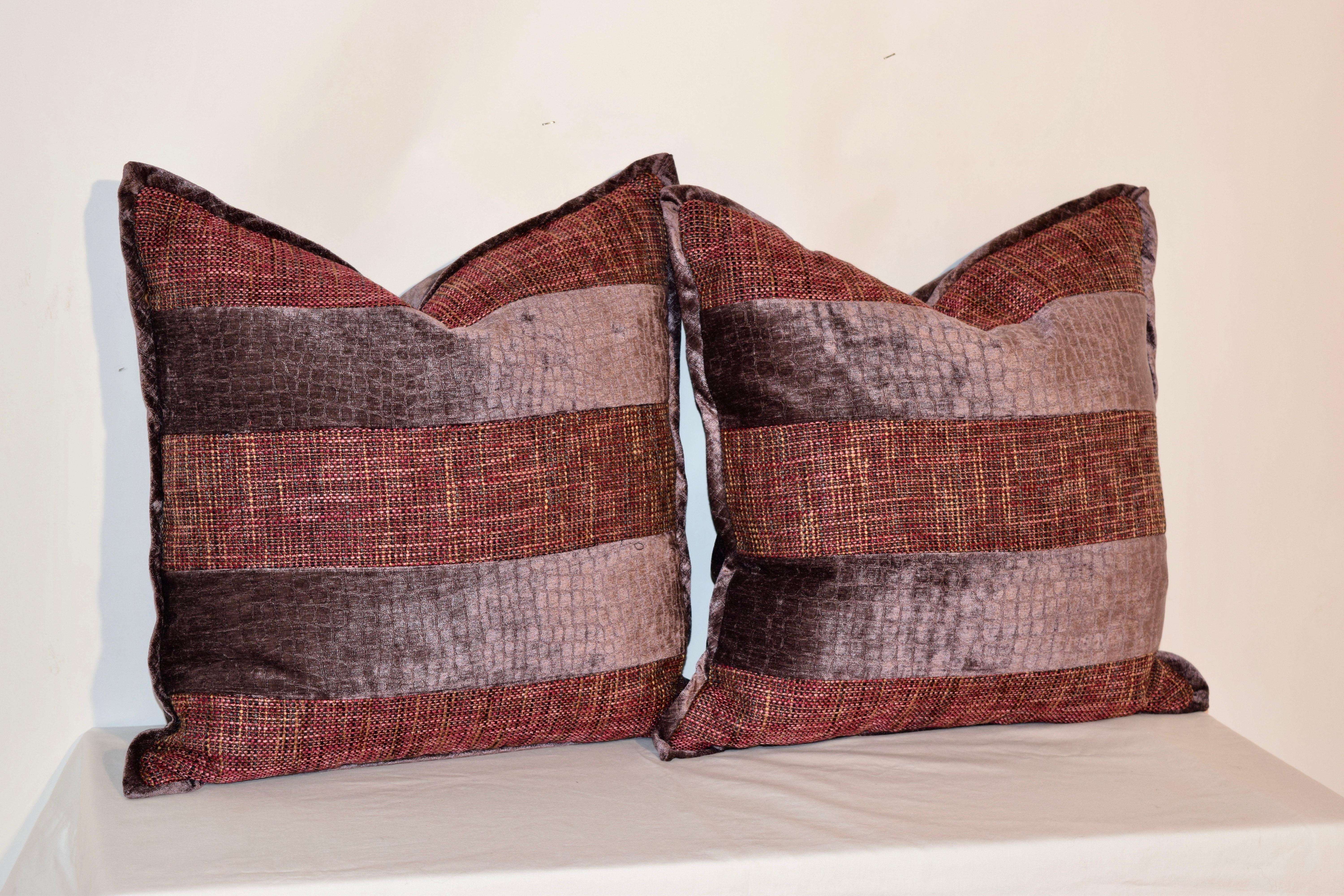 Handmade pillows made from dusty grape velvet and woven multicolored fabrics with a contrasting velvet welt. The covers have hidden zippers and the inserts are removable. Dry clean only.