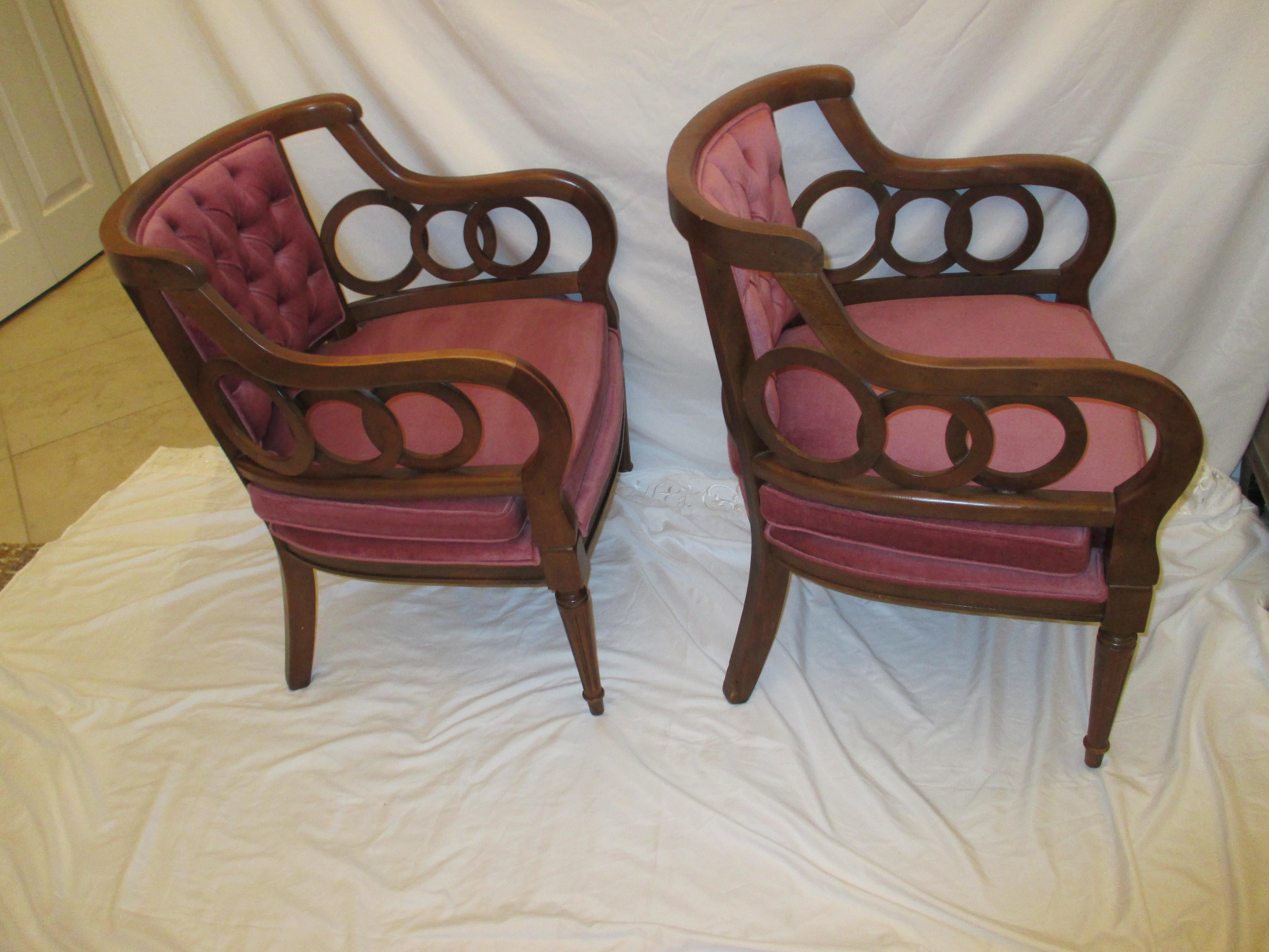 Pair of plum velvet upholstered barrel backed Hollywood Regency circle armchairs. Chairs are dark stained and have original upholstery in good condition.