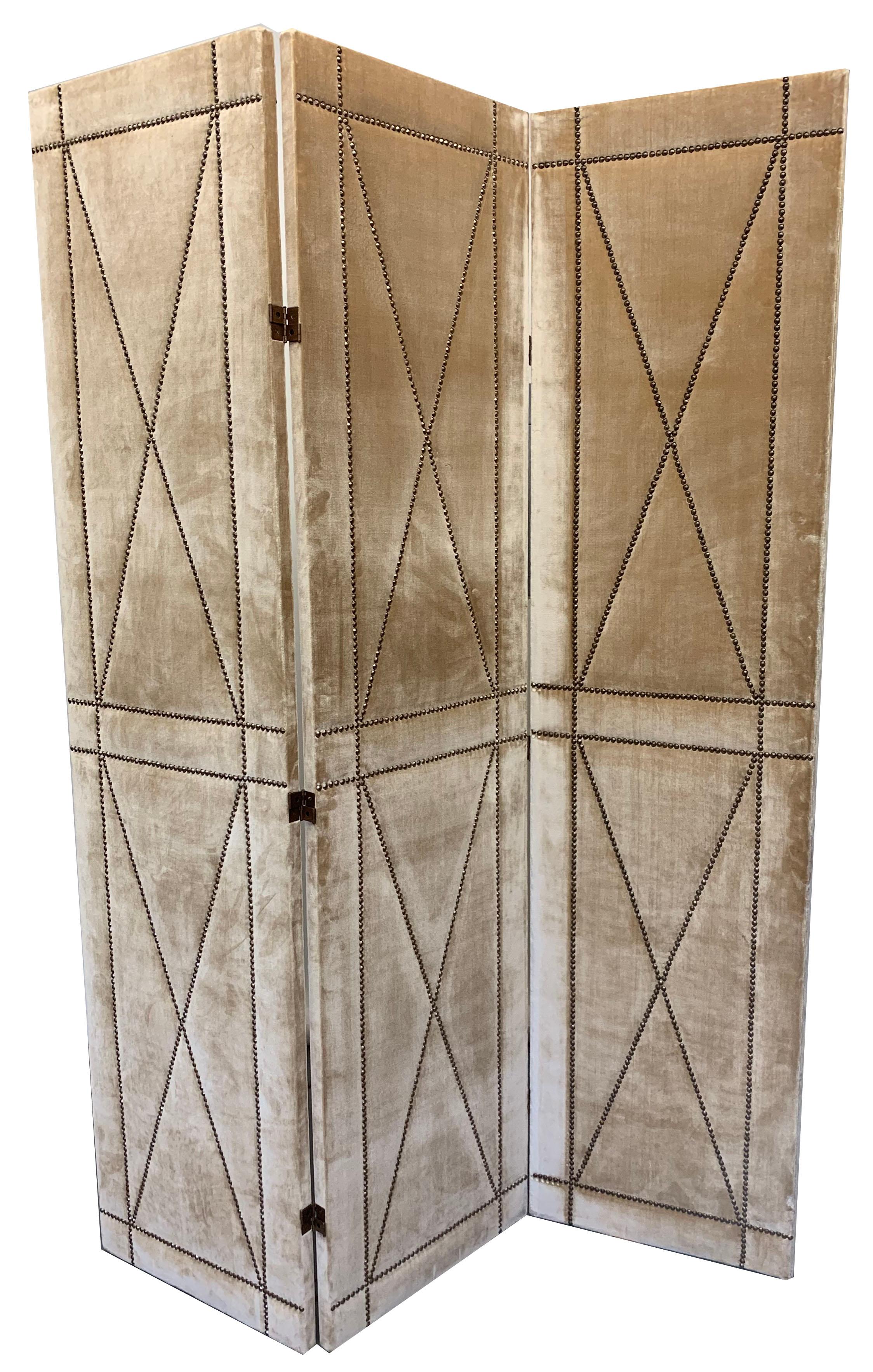 Pair of velvet screens with nailhead detail designed by Juan Montoya. Upholstered in a beige velvet with a brass nailhead trim. They can be put together for a total span of 10.5'.

Property from esteemed interior designer Juan Montoya. Juan